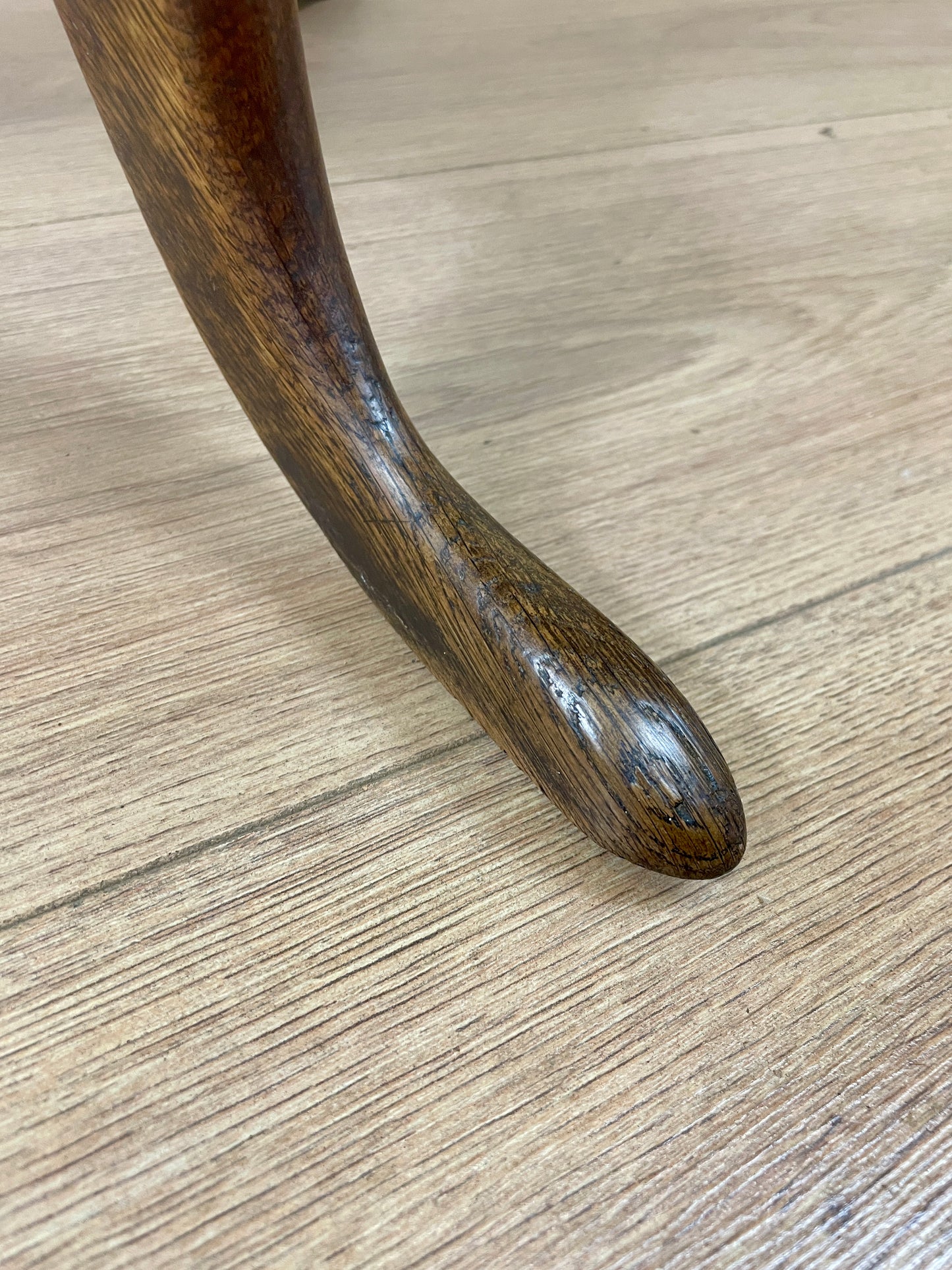 Close-up of a wooden table leg on a wooden floor