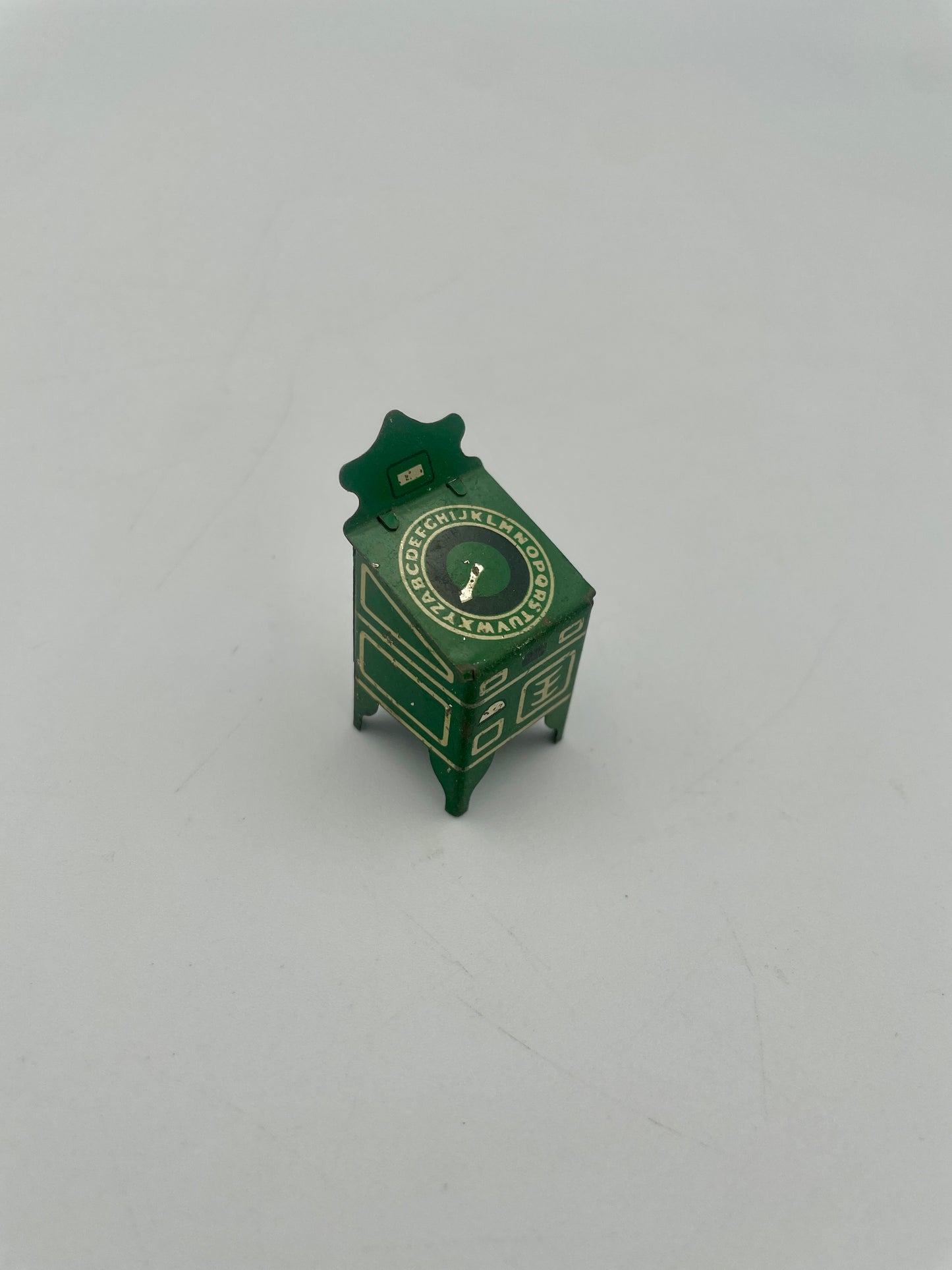 Small green toy cabinet on a white background