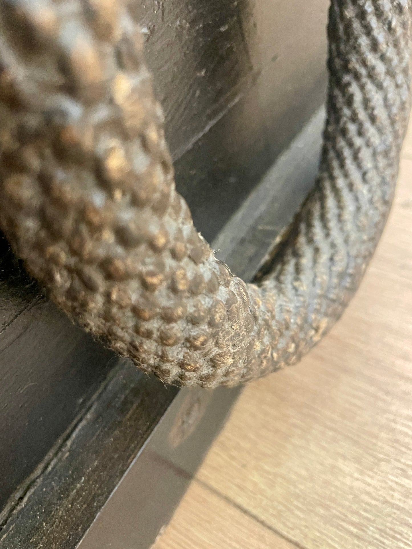 Close-up of a textured metal ring on a wooden surface
