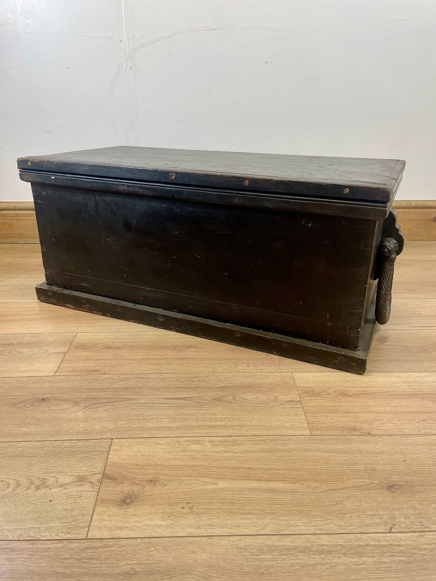 Wooden trunk on a wooden floor with a white wall background