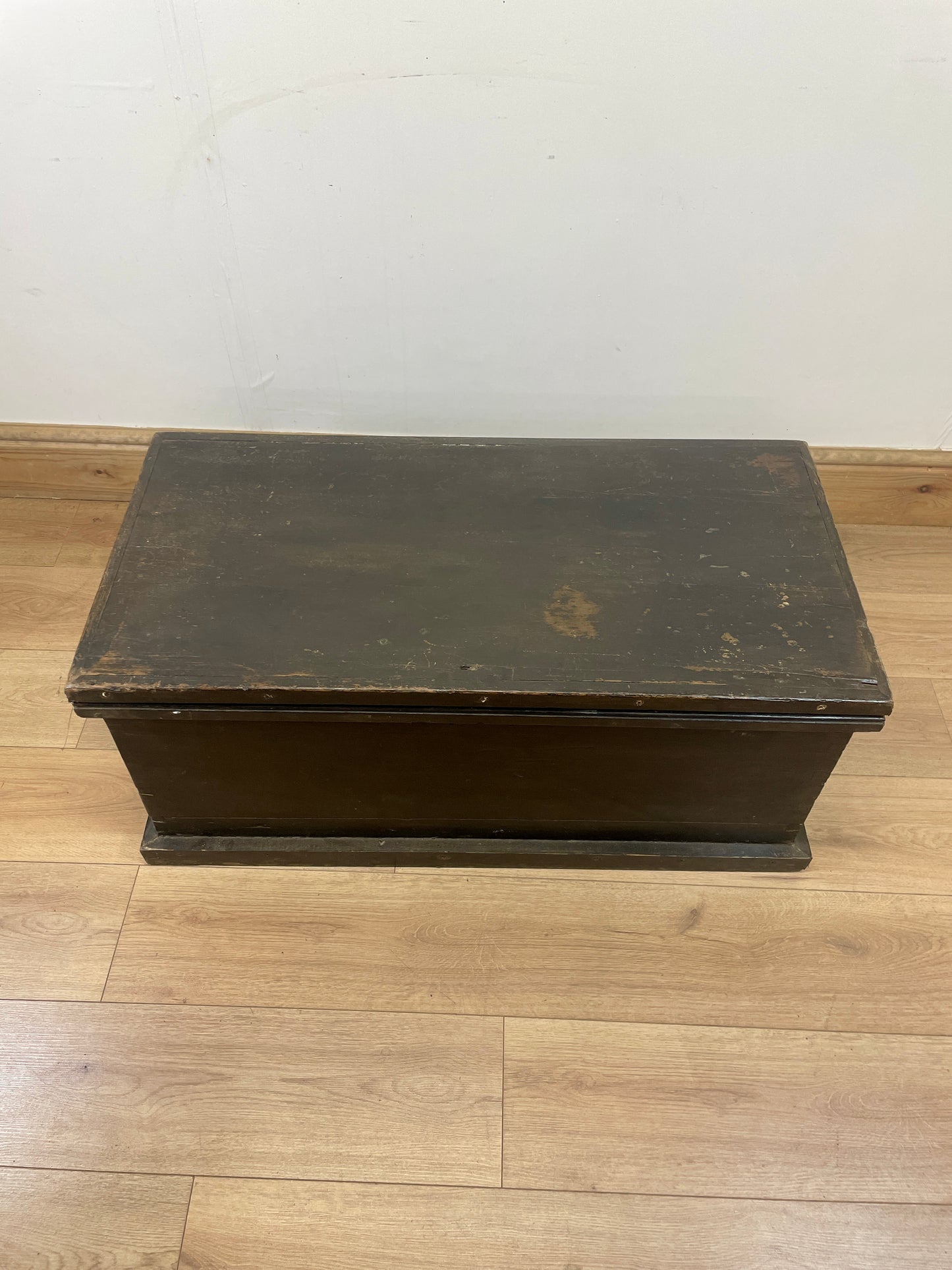 Vintage wooden step stool on a wooden floor with a white wall background