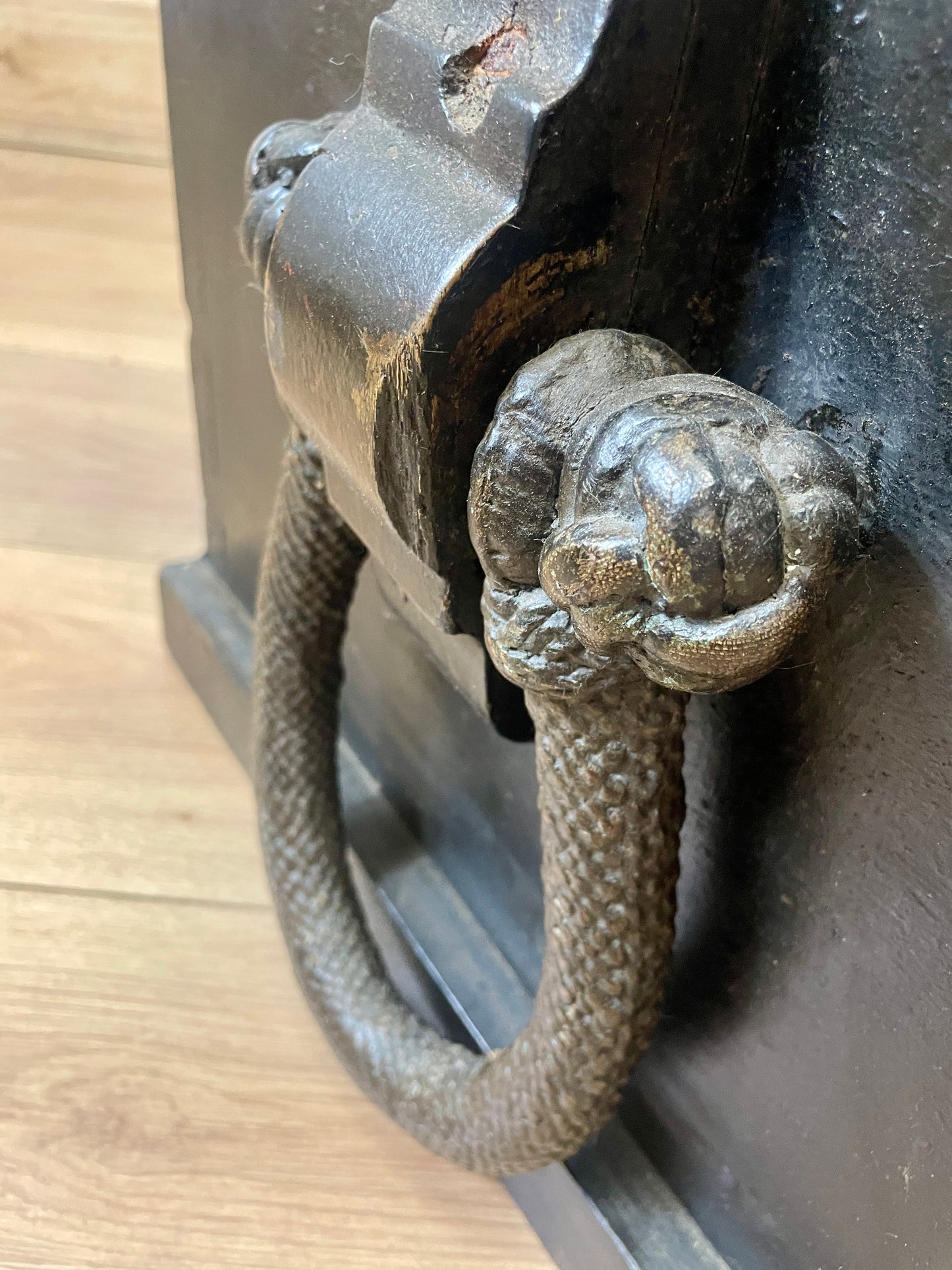 Metal door handle on a wooden surface