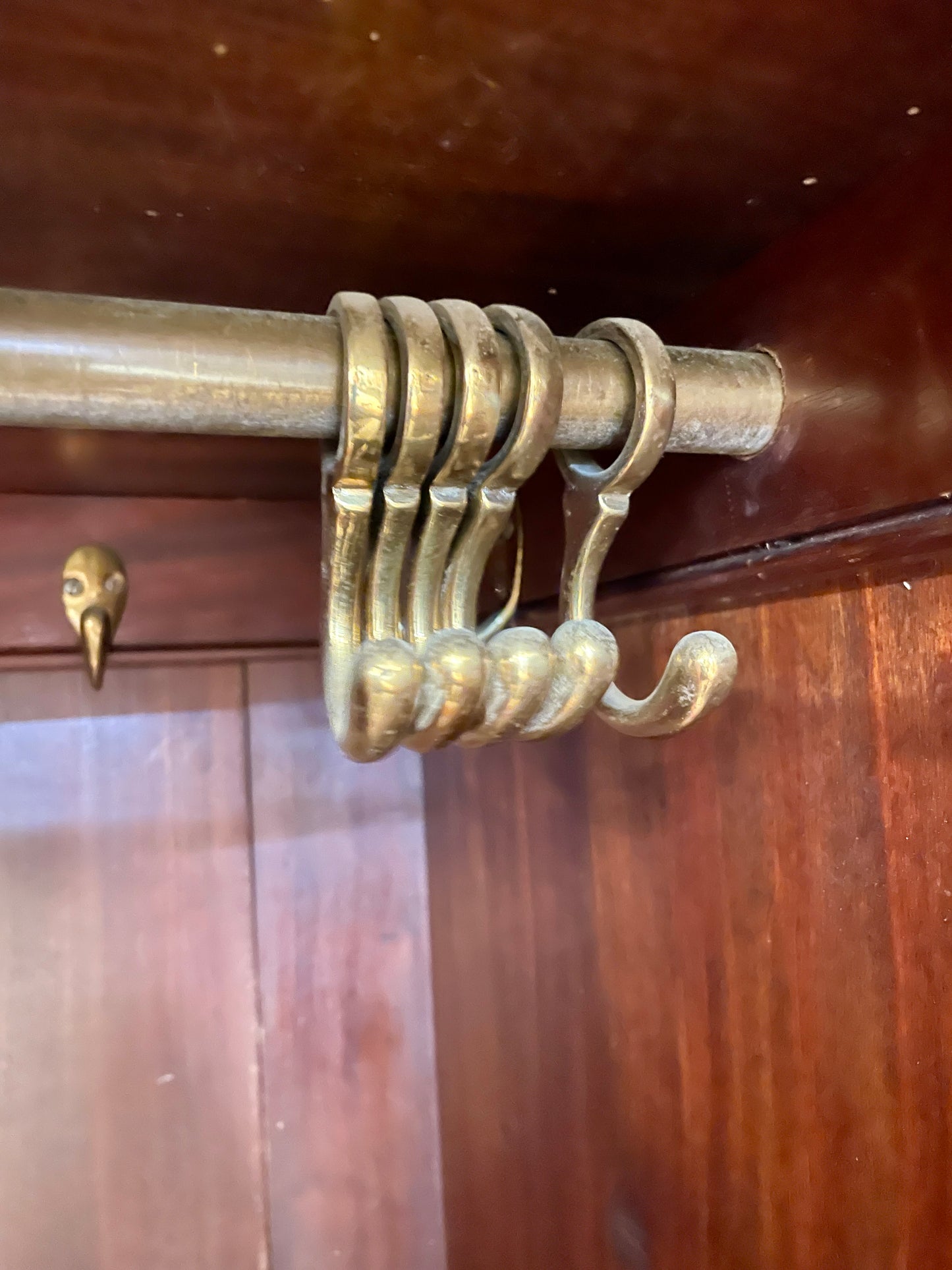 Brass curtain rod with decorative bracket on a wooden door