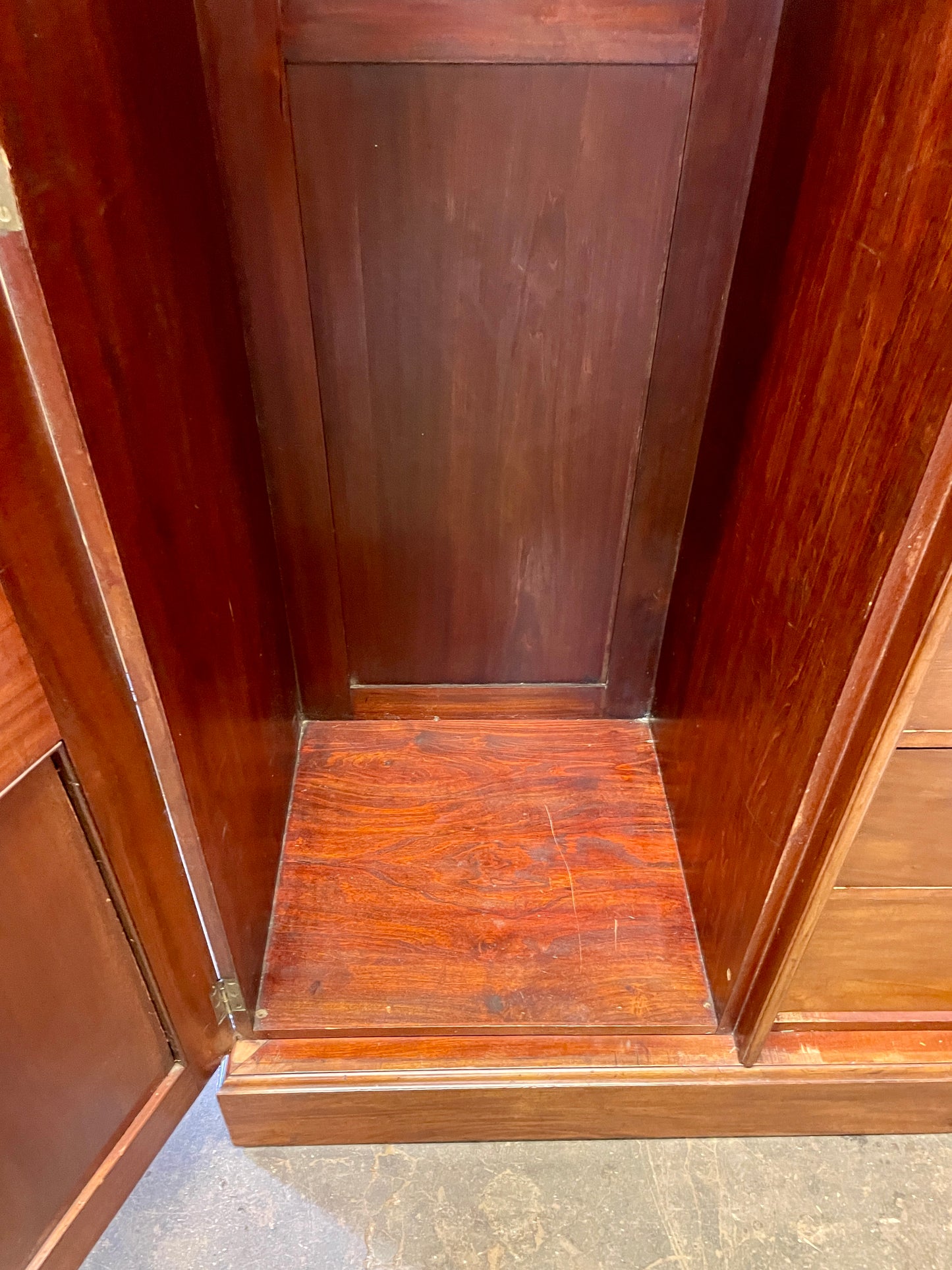 Wooden cabinet with open doors showing a dark brown finish.