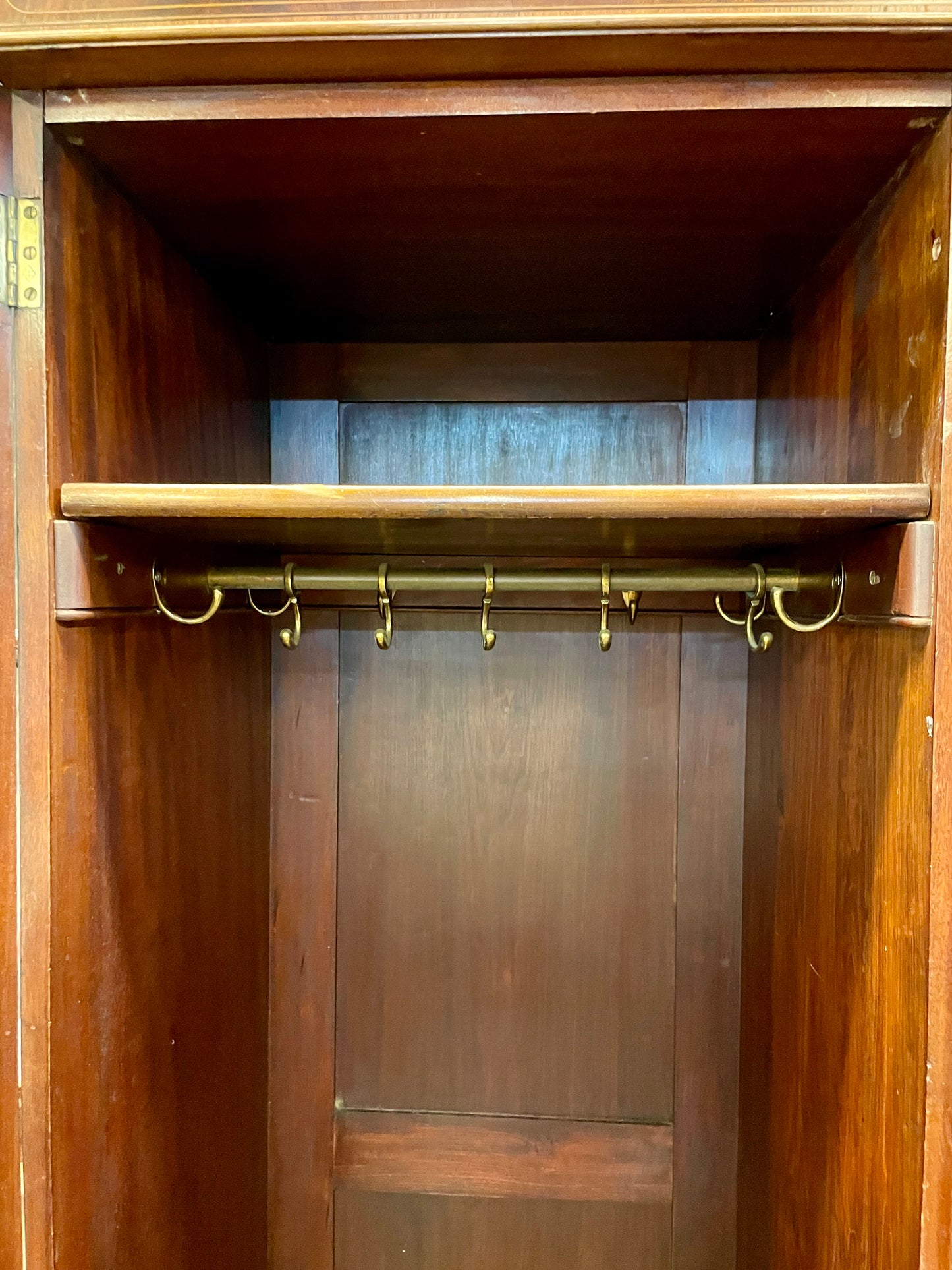 Wooden wardrobe with brass hooks on a wooden door