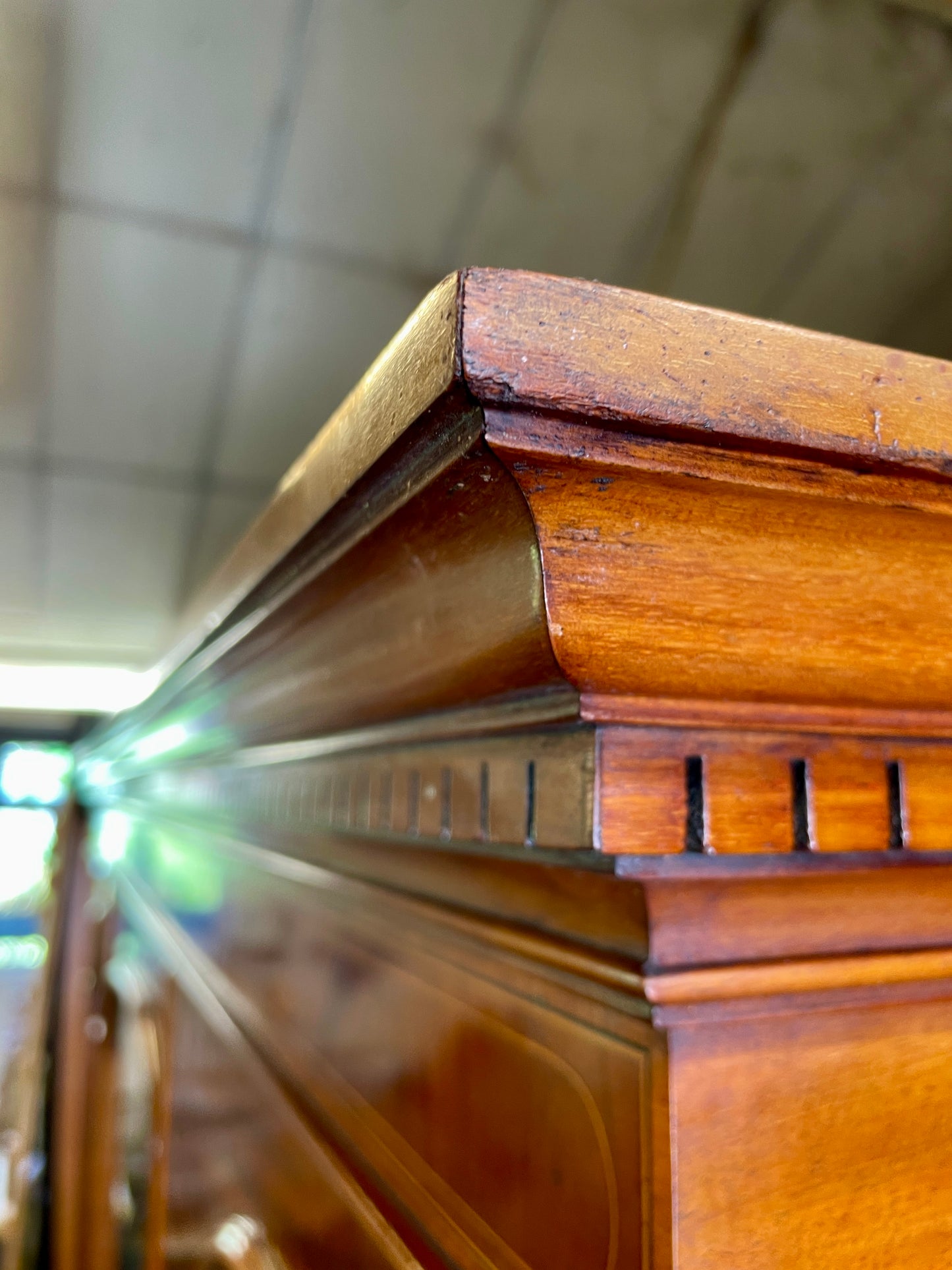 Close-up of a wooden surface with intricate carvings, possibly part of a larger piece of furniture.