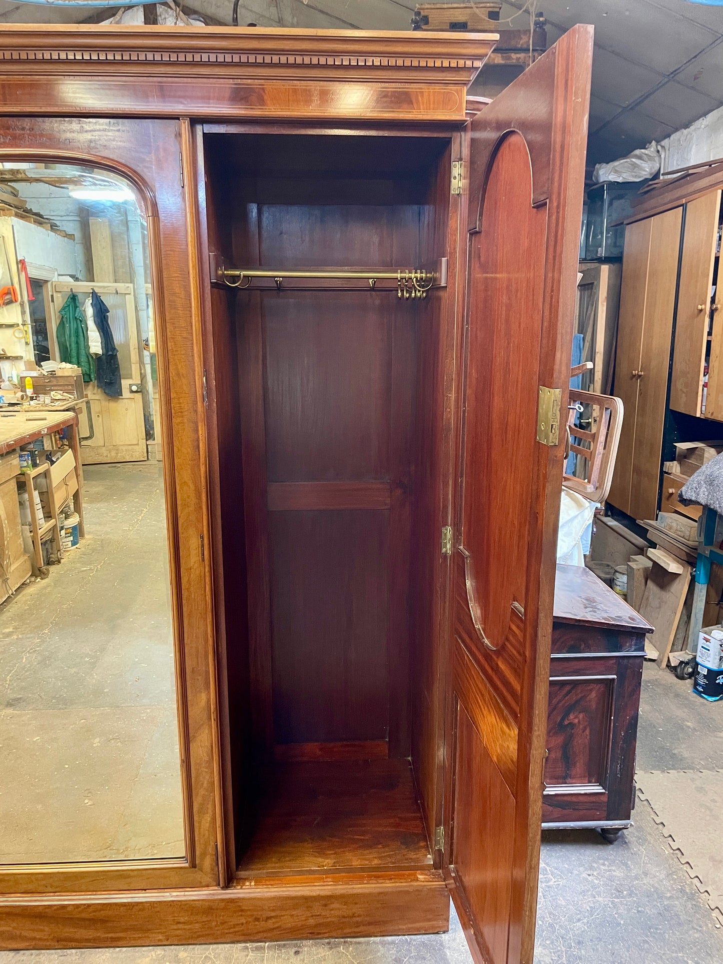Wooden wardrobe with mirrored door in a storage or warehouse setting