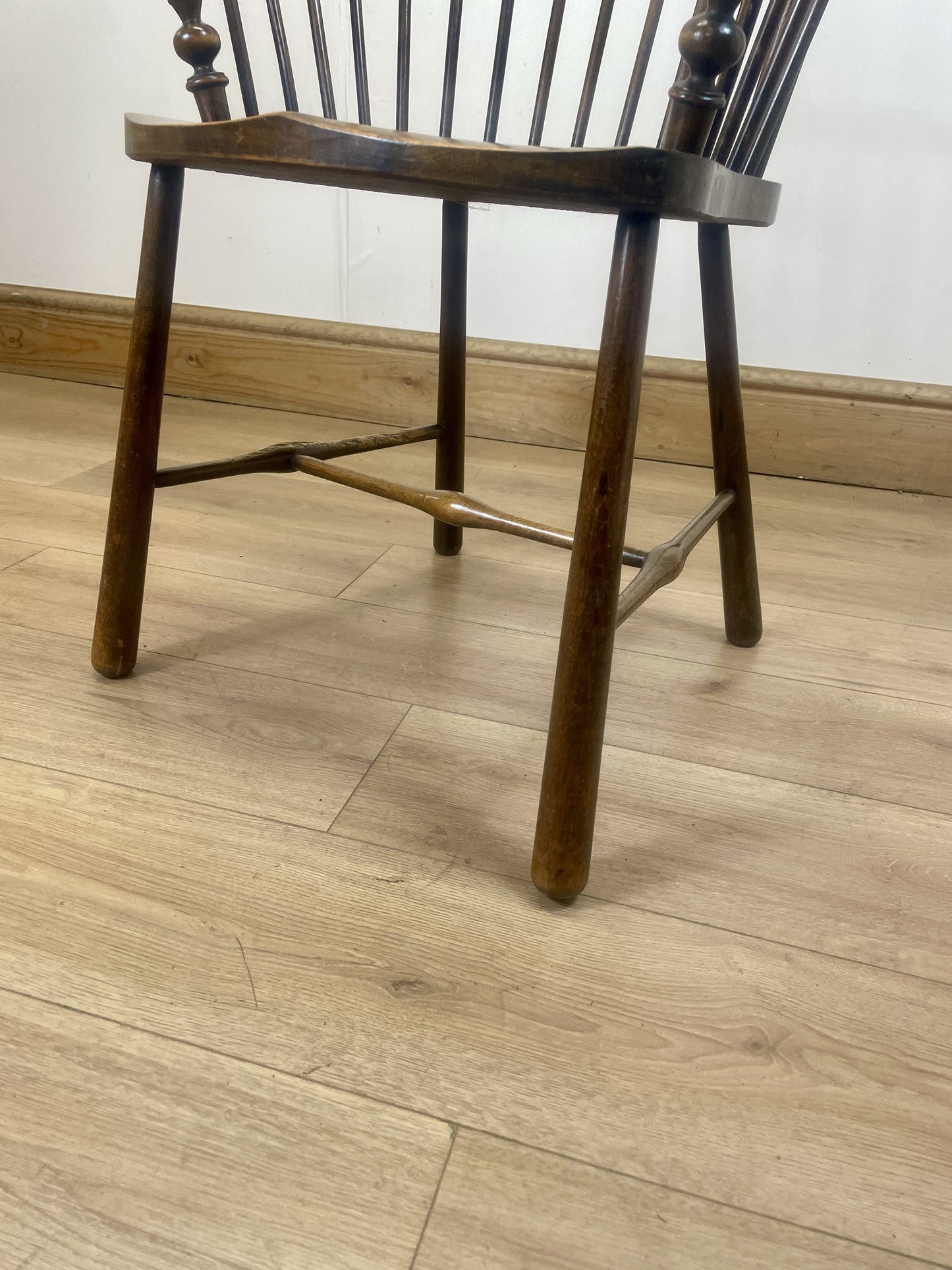 Wooden chair on a wooden floor with a white wall background