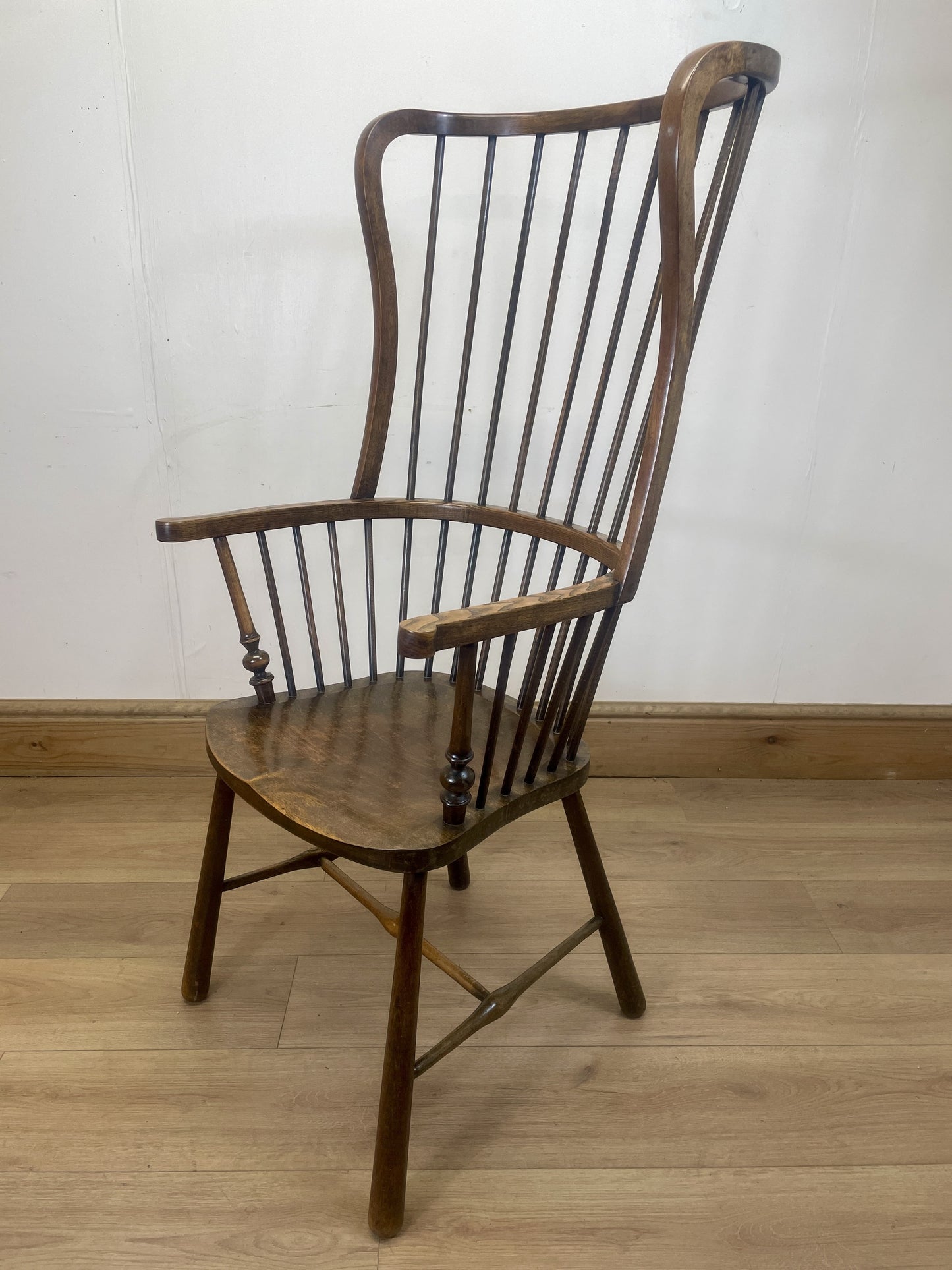 Wooden armchair with a white wall and wooden floor background