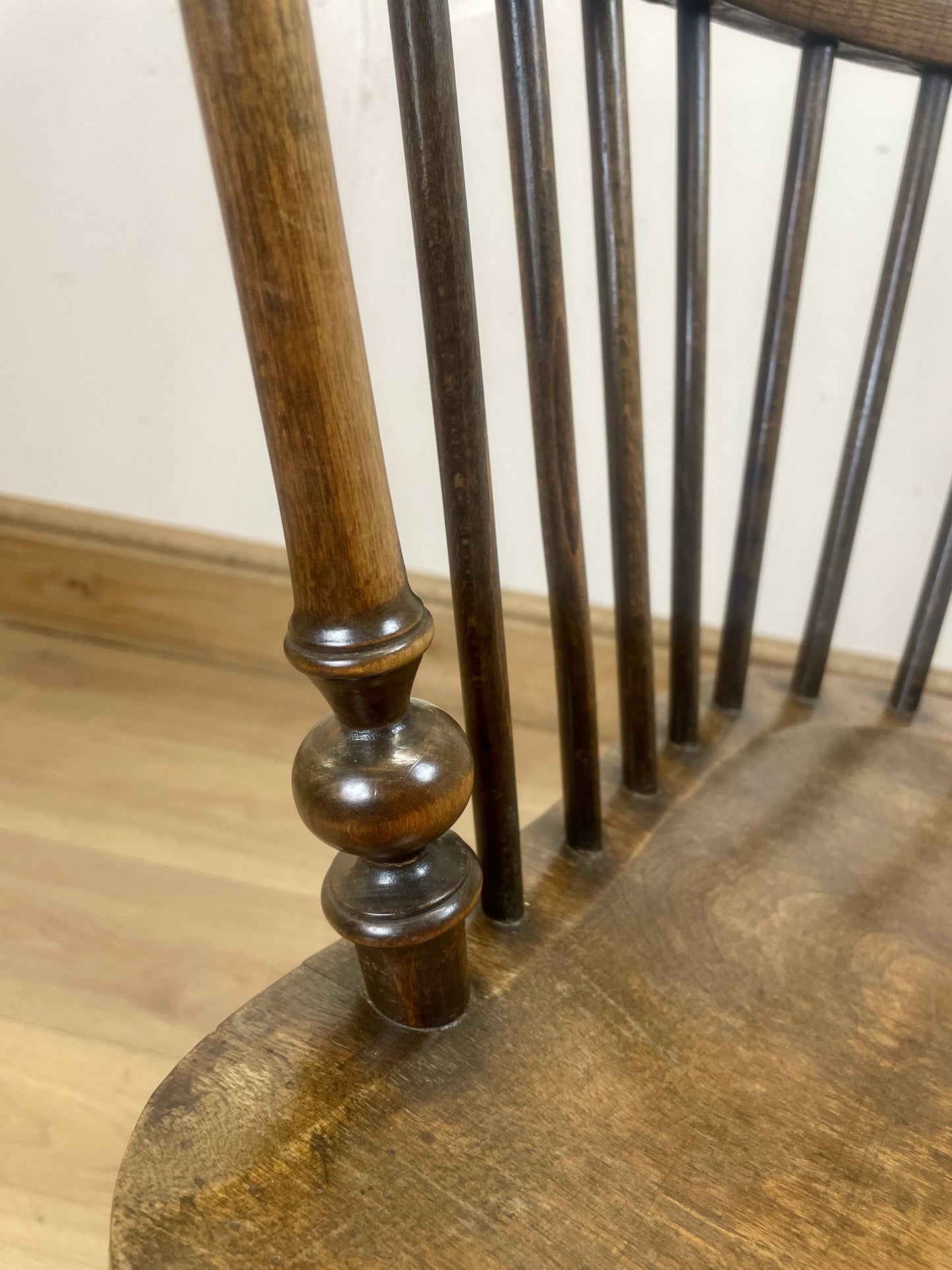 Close-up of a wooden chair with a focus on the leg and seat.