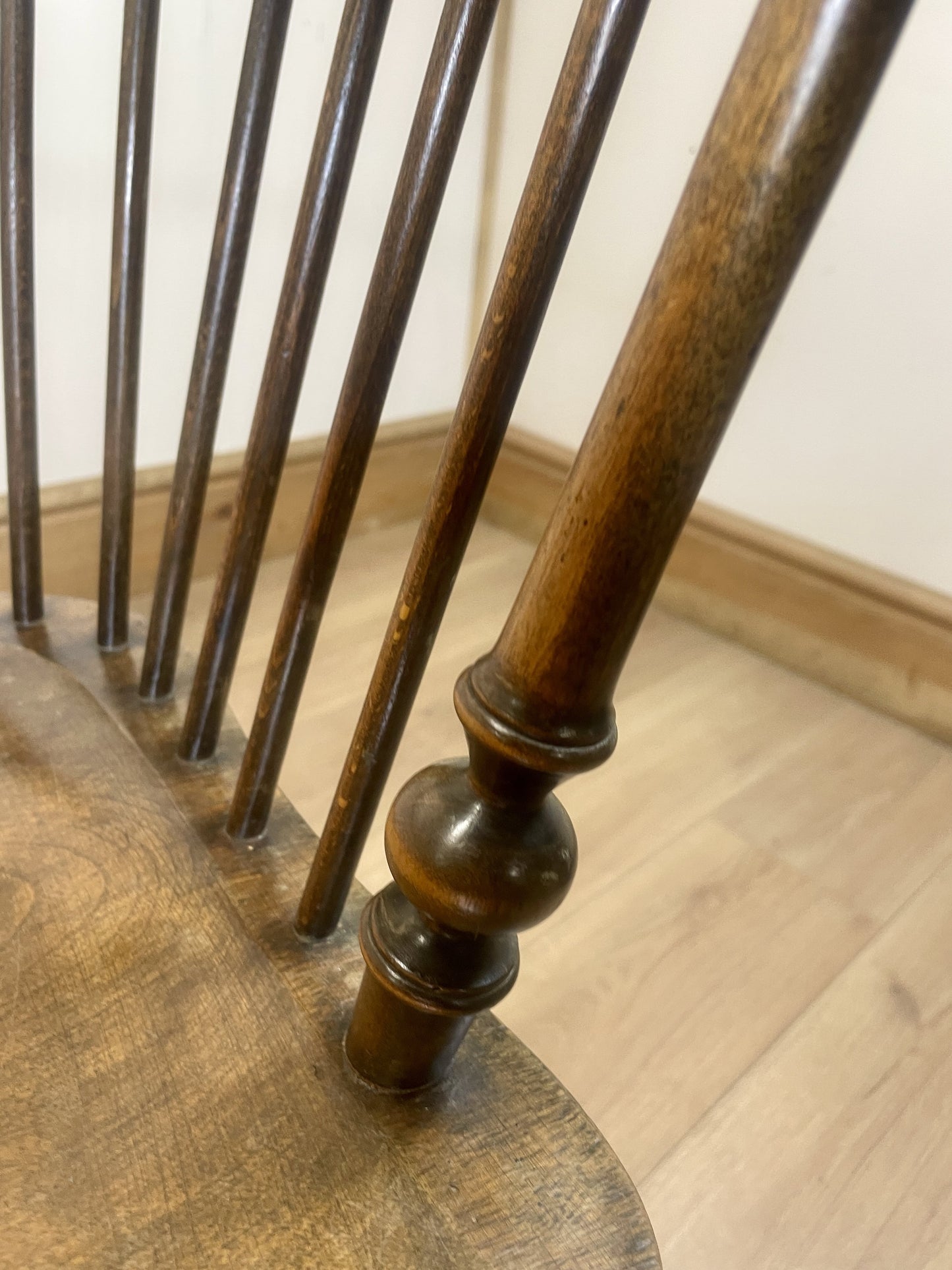 Close-up of a wooden chair with wooden legs on a wooden floor.