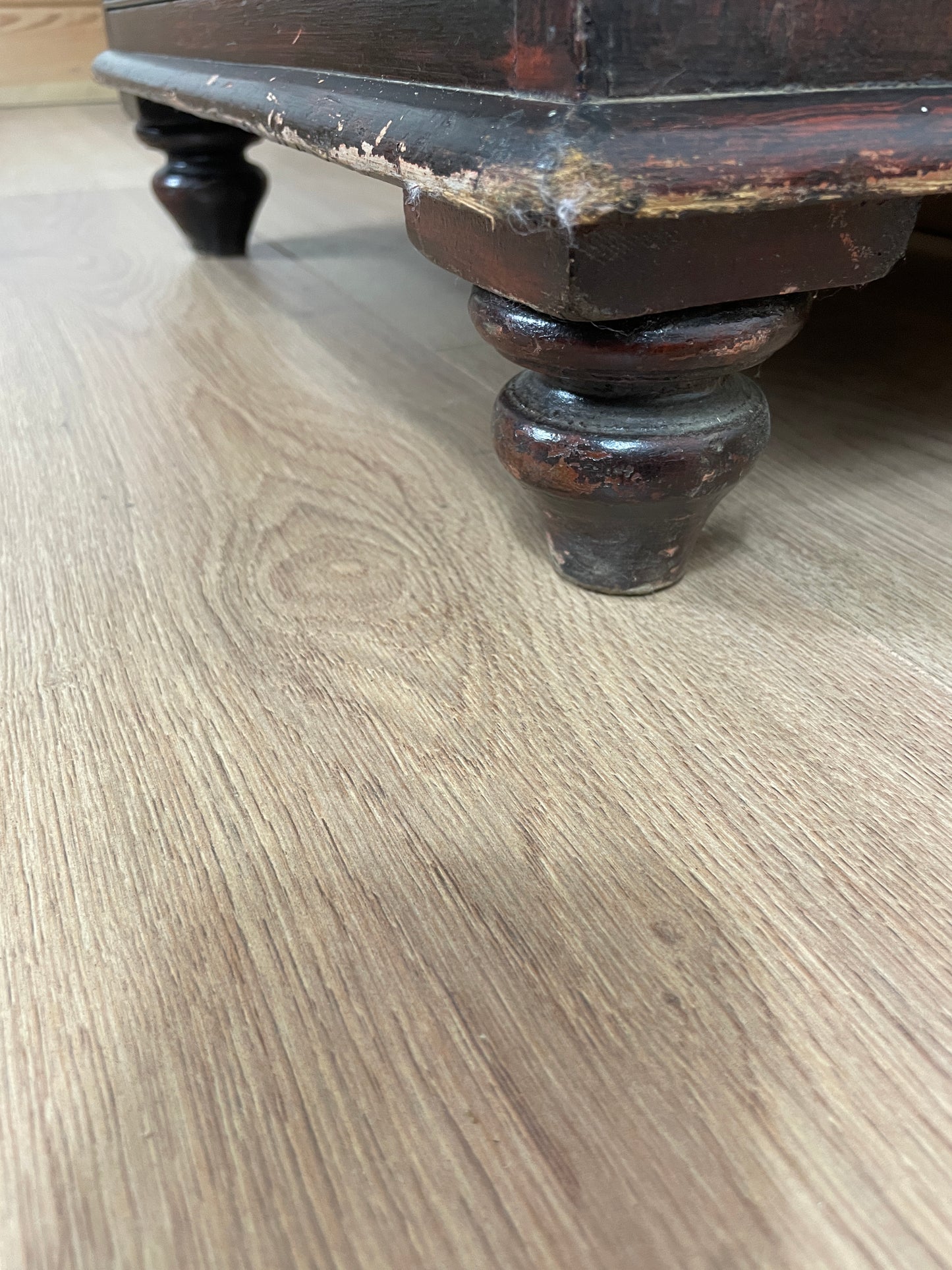 Close-up of a wooden surface with a dark brown knob.