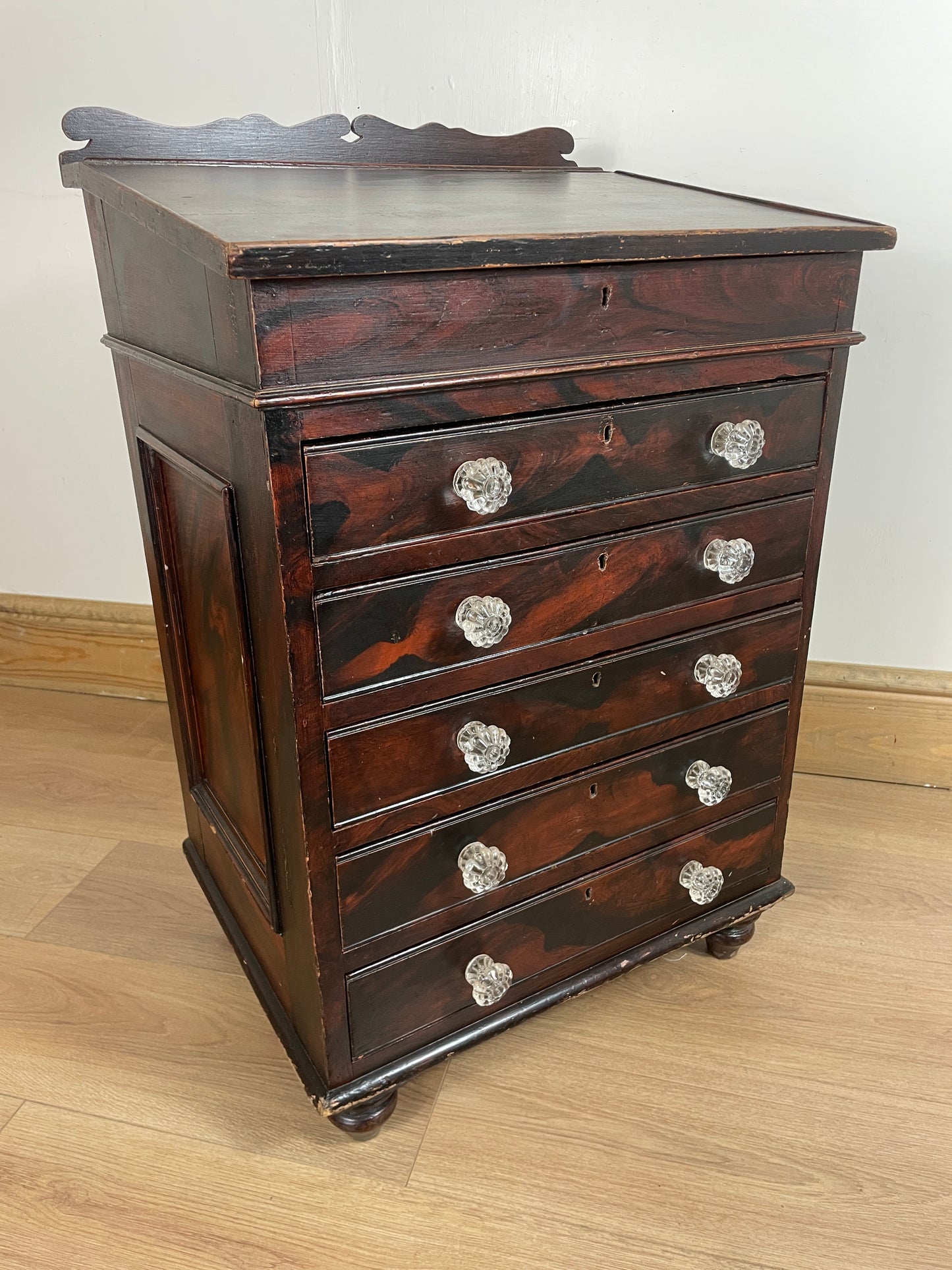 Wooden cabinet with glass knobs on a wooden floor