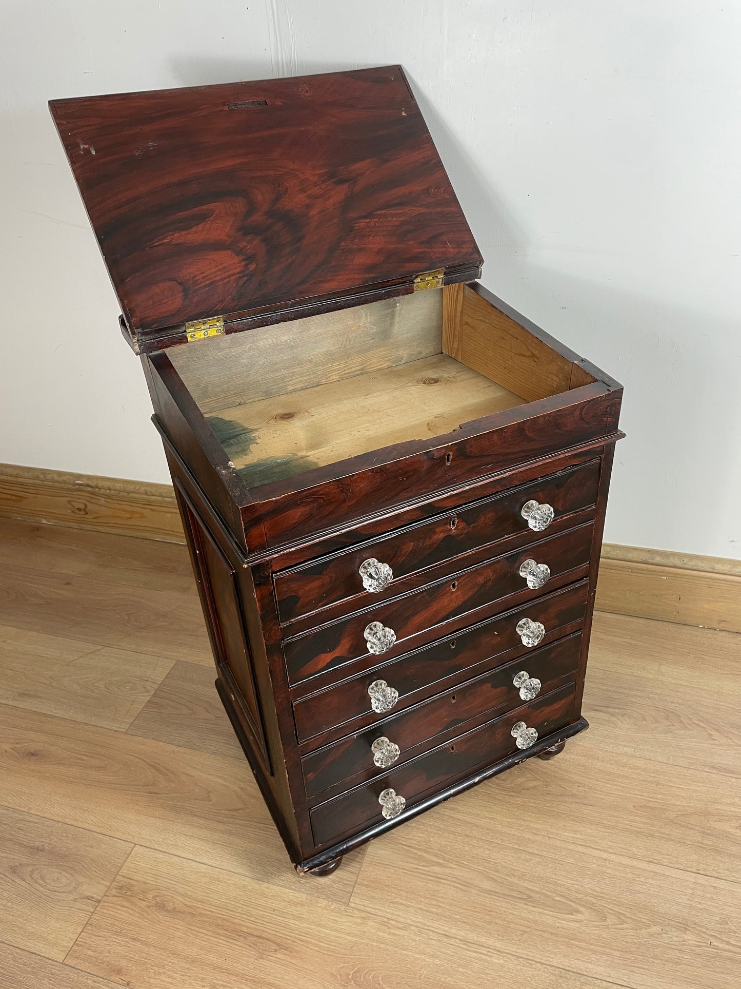Wooden jewelry box with glass lid on a wooden floor