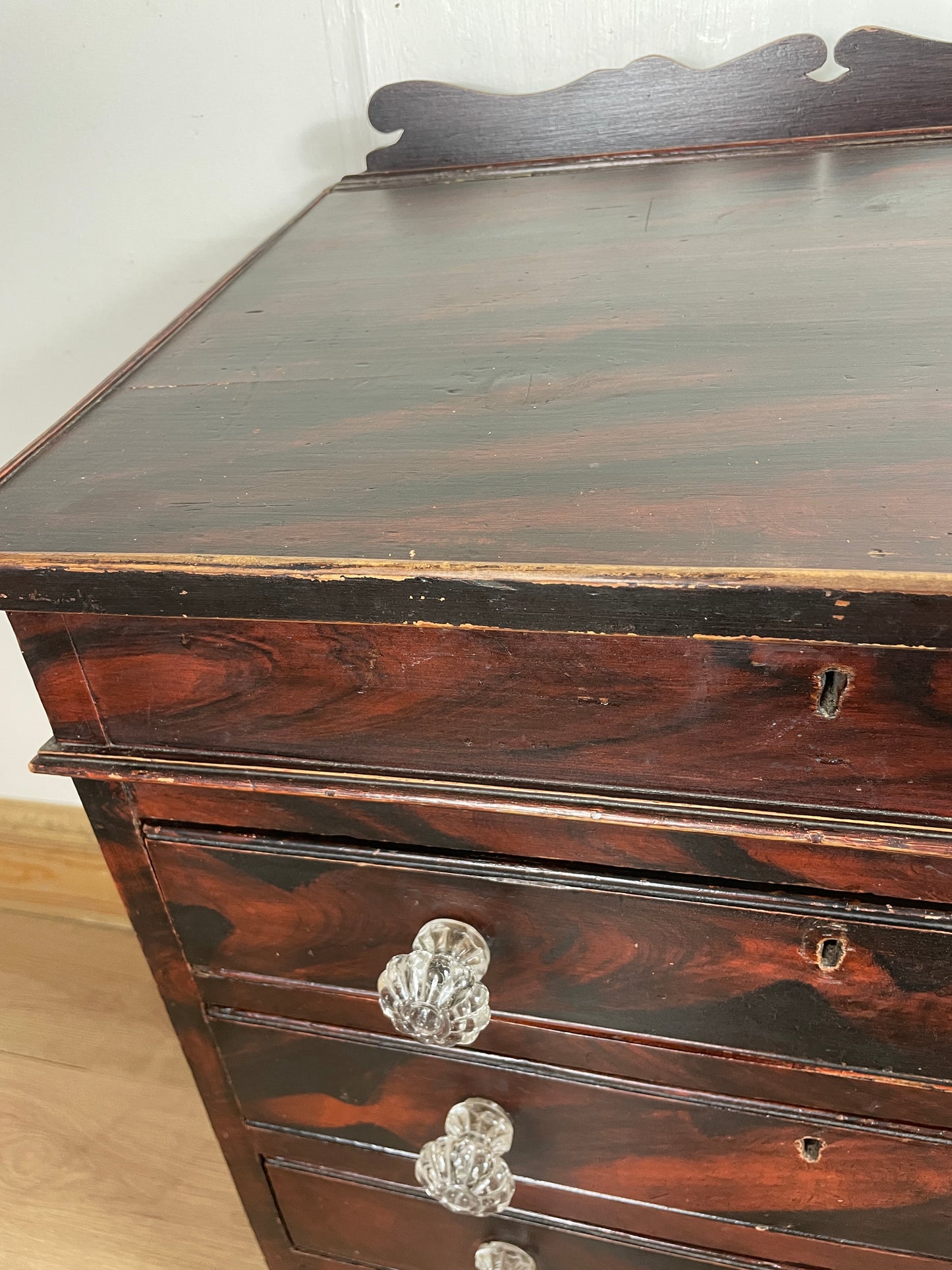 Close-up of a wooden cabinet with glass knobs on a white background