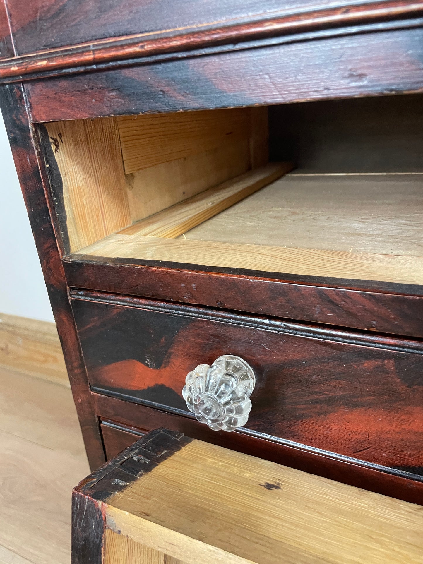 Close-up of a wooden cabinet with a glass knob