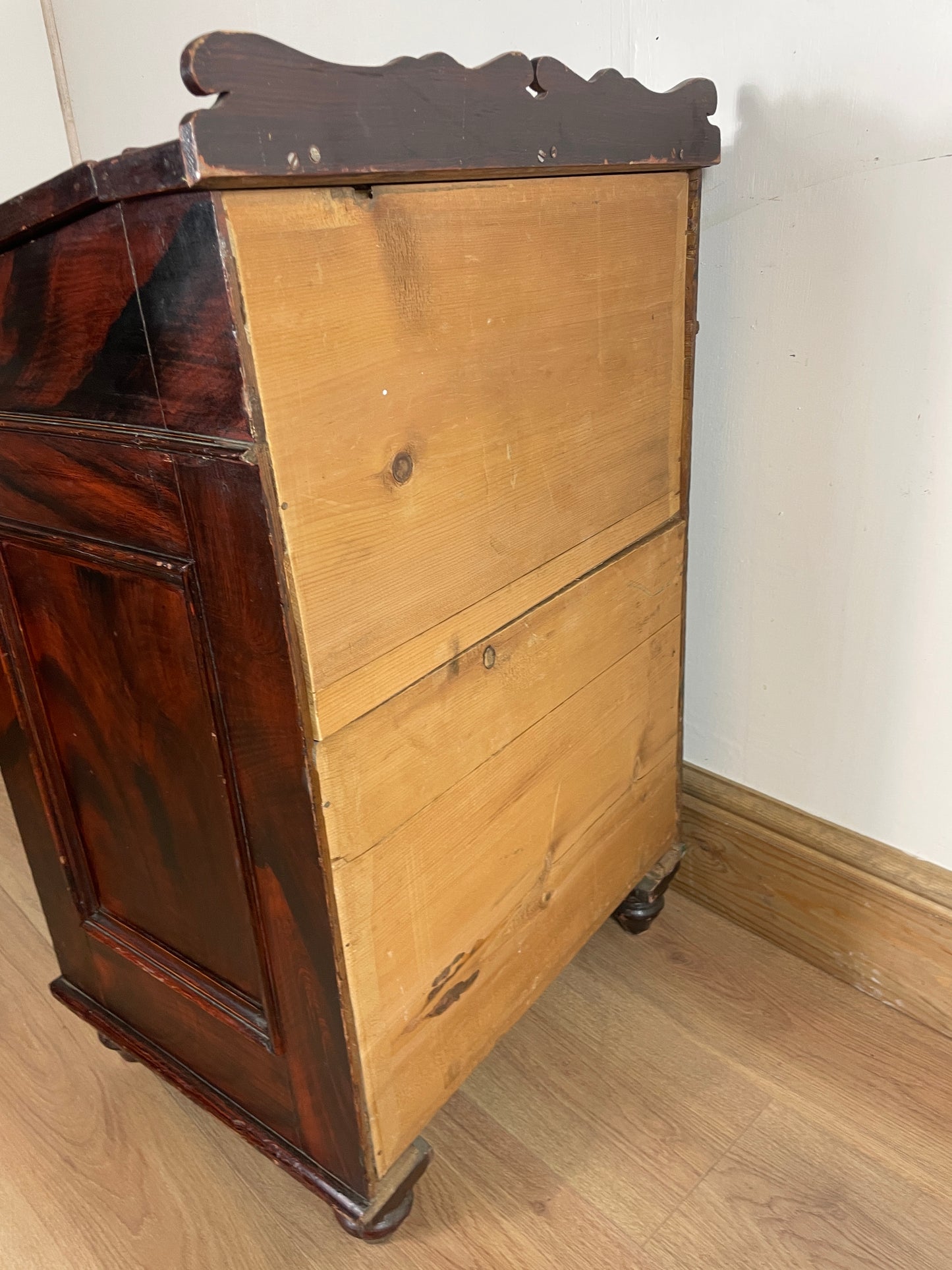 Wooden cabinet with a visible grain pattern on a wooden floor.
