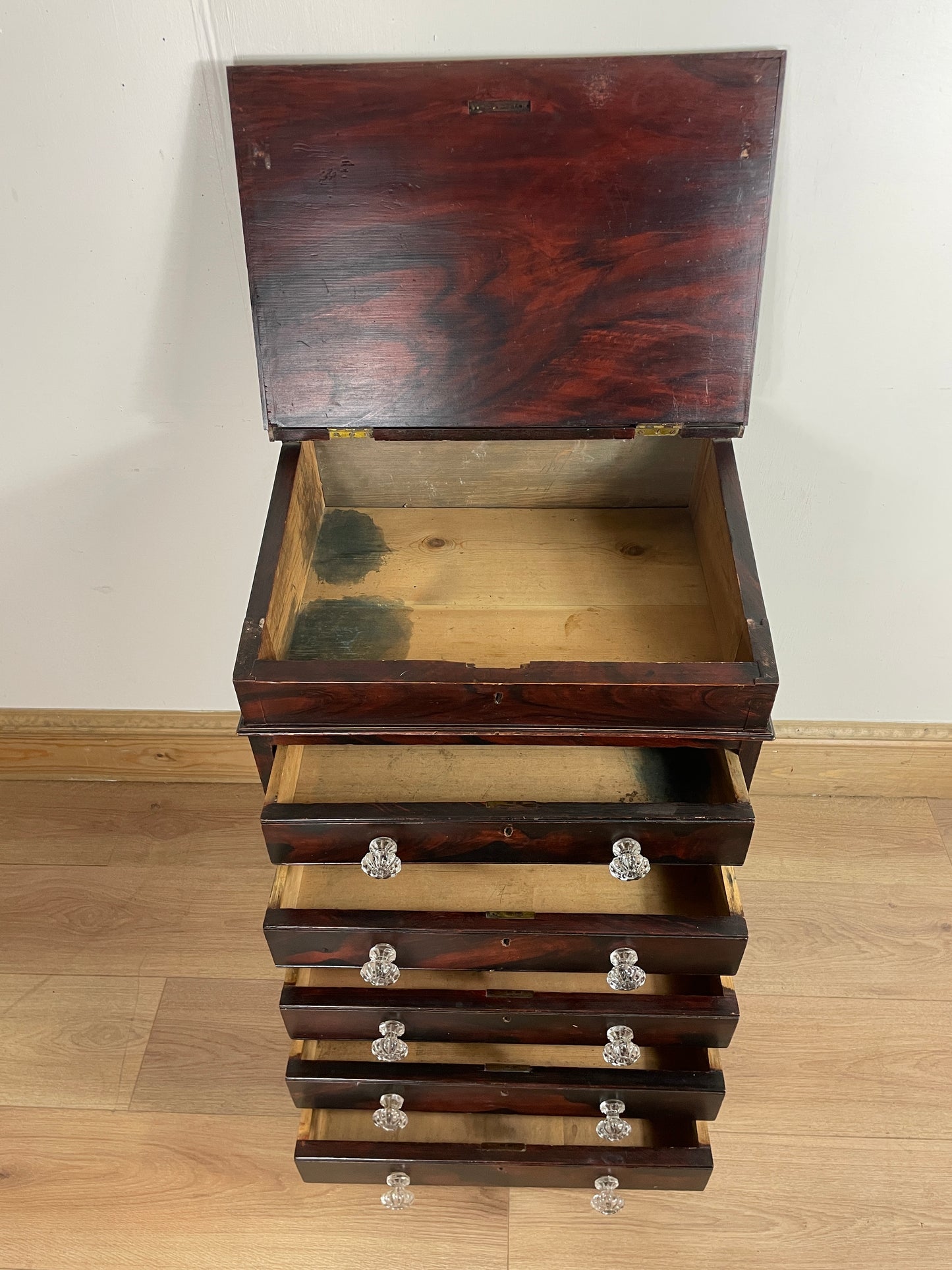Wooden wall-mounted shelf with adjustable brackets on a wooden panel.