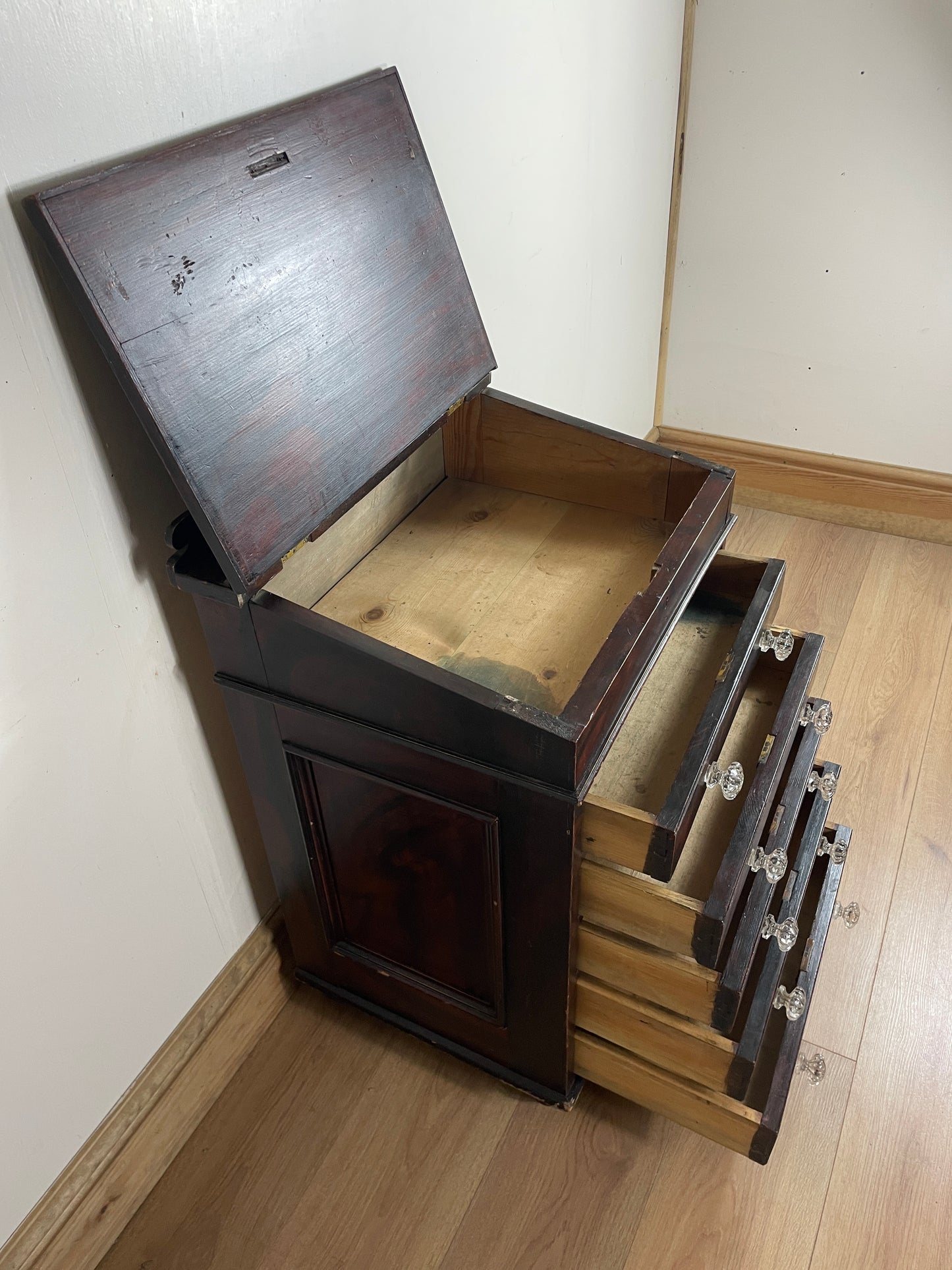 Wooden crate with a lid open on a light-colored floor.
