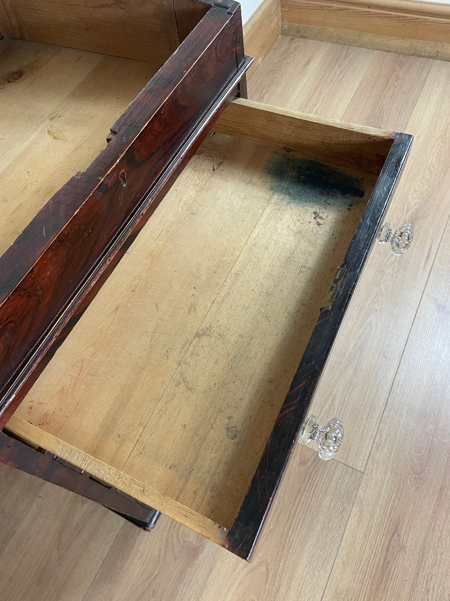 Wooden box with a mirror inside on a wooden floor