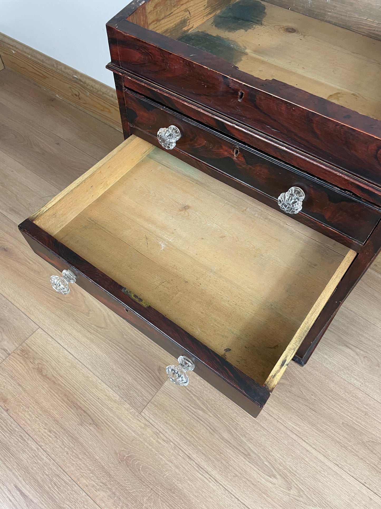 Wooden jewelry box with glass knobs on a wooden surface