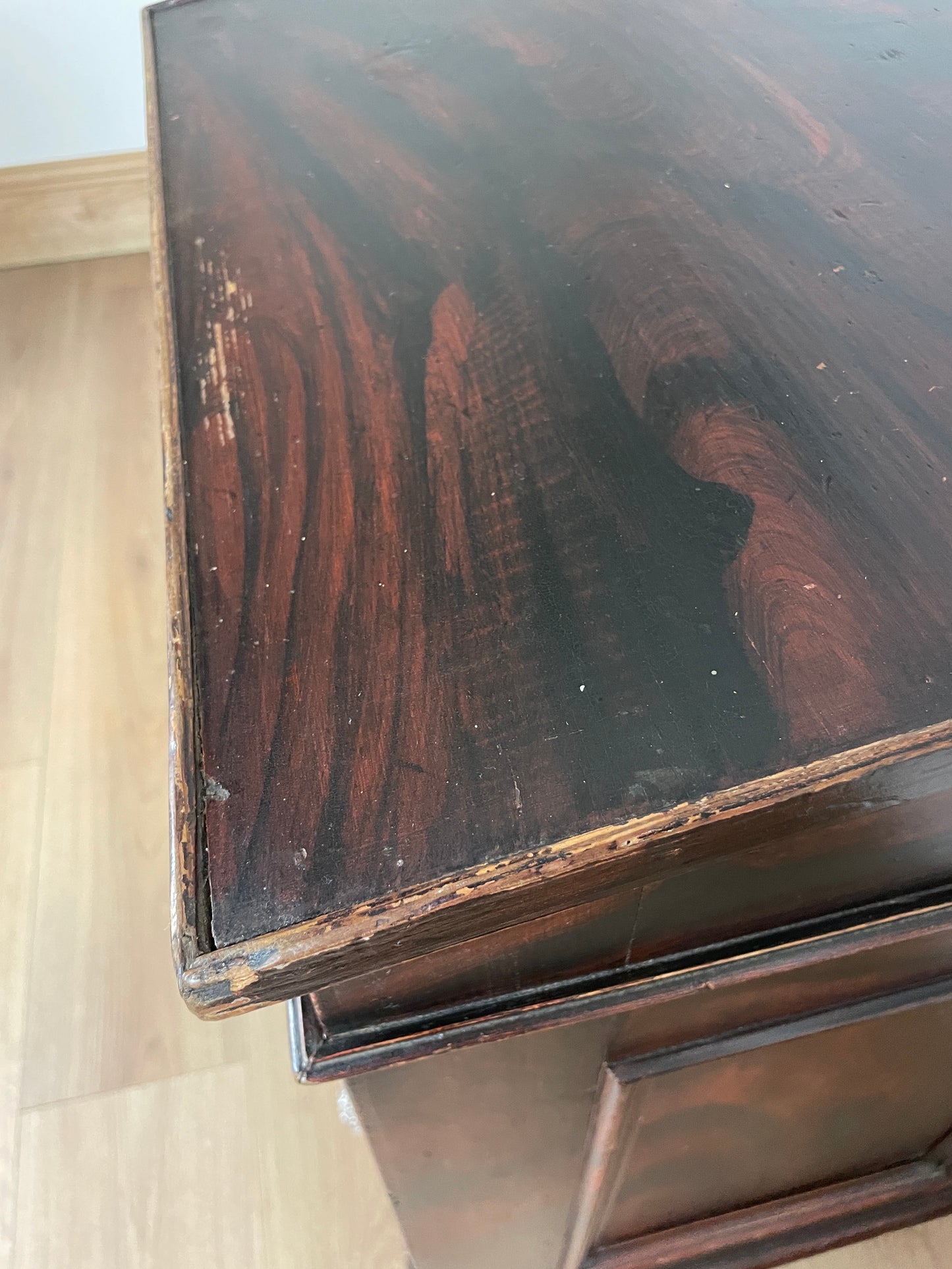 Close-up of a dark wooden surface with visible grain and texture.