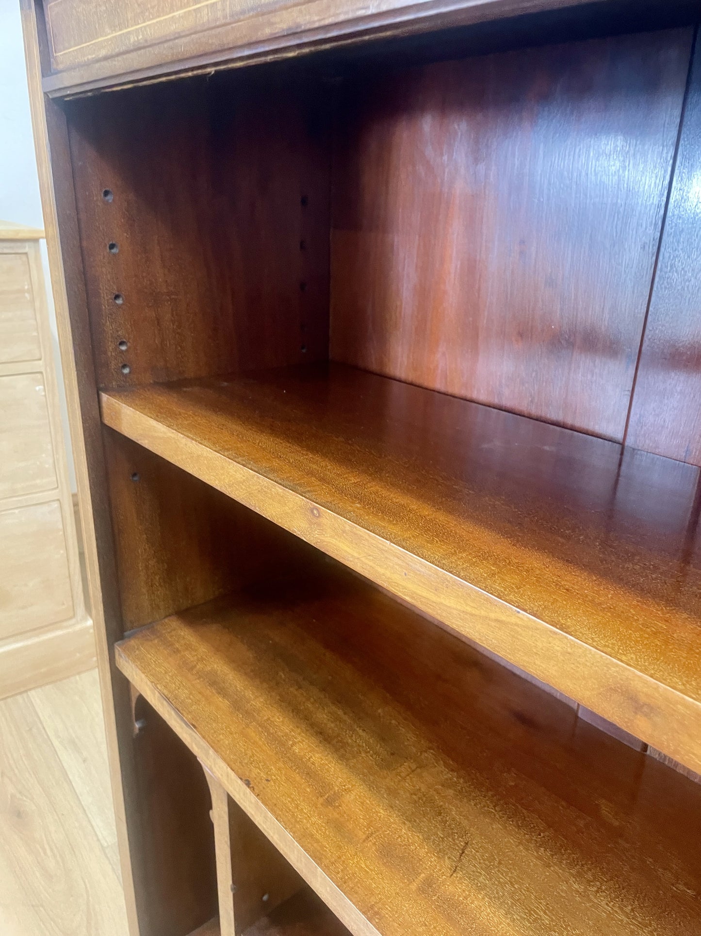 Wooden bookshelf with two shelves against a neutral wall.
