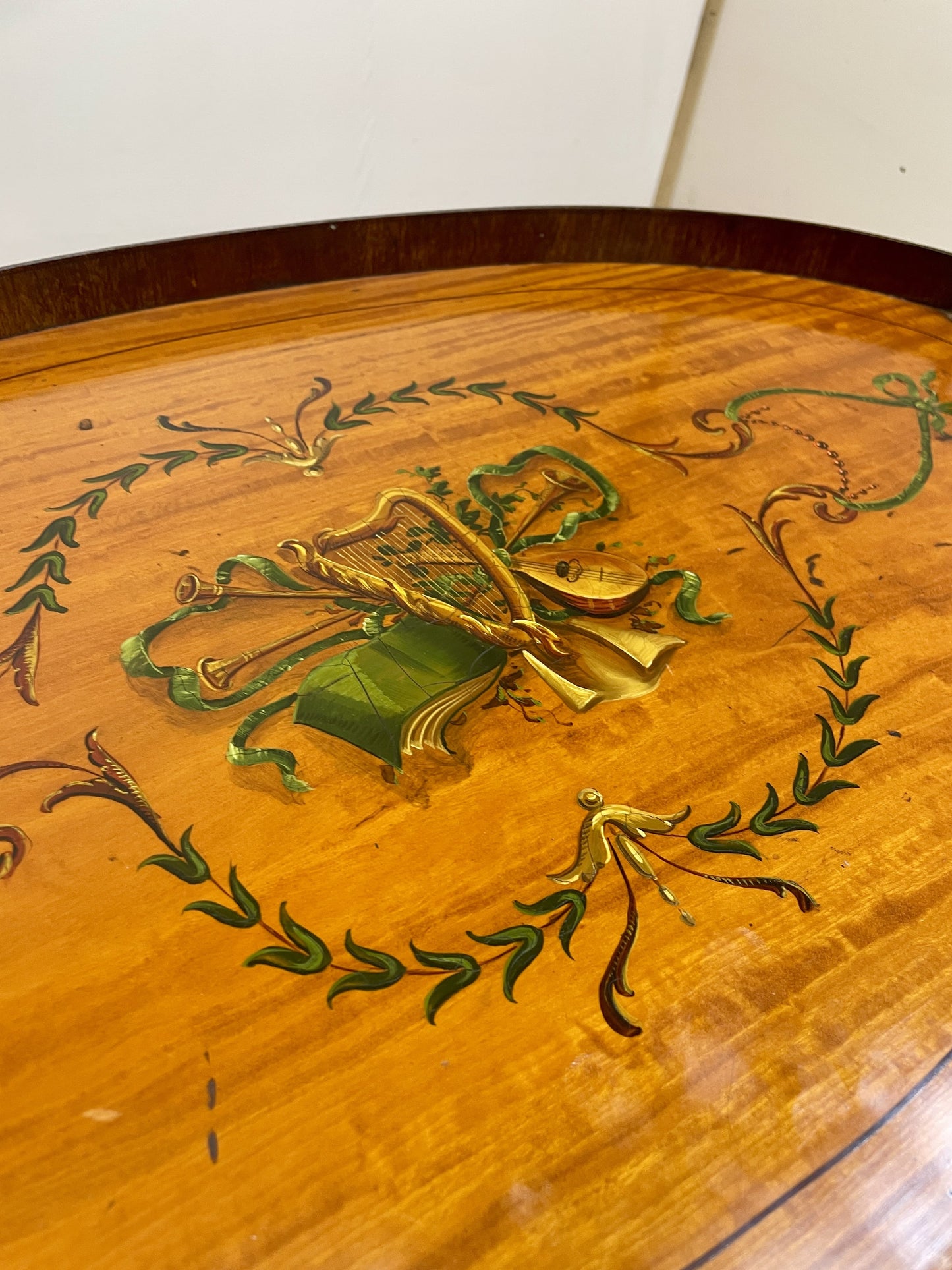 Wooden surface with intricate green and gold designs on a plain background