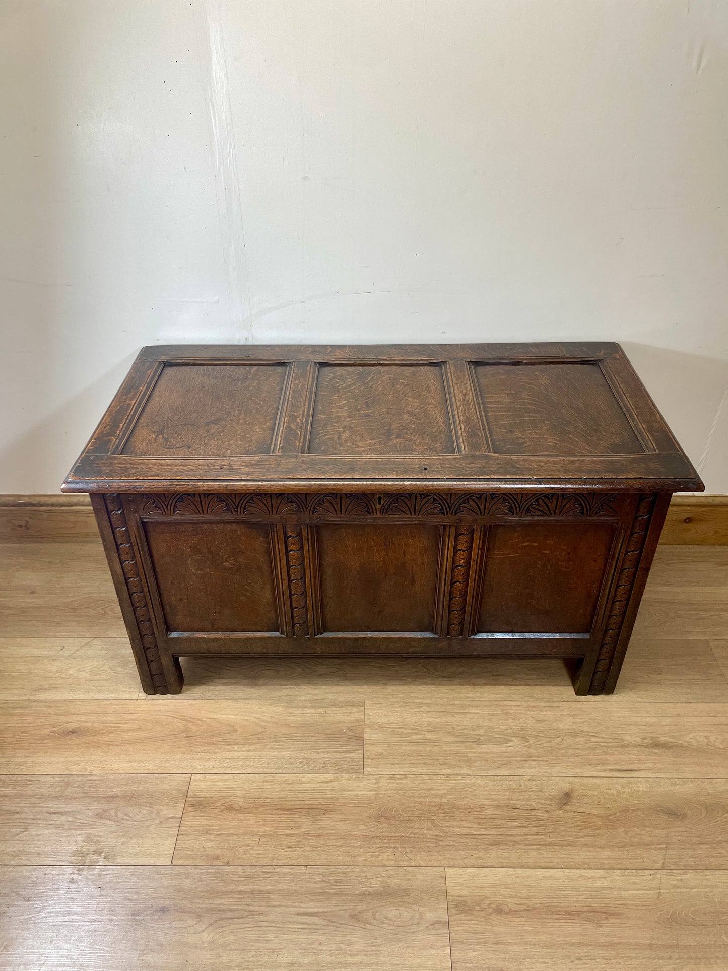 Wooden chest on a wooden floor with a white wall background