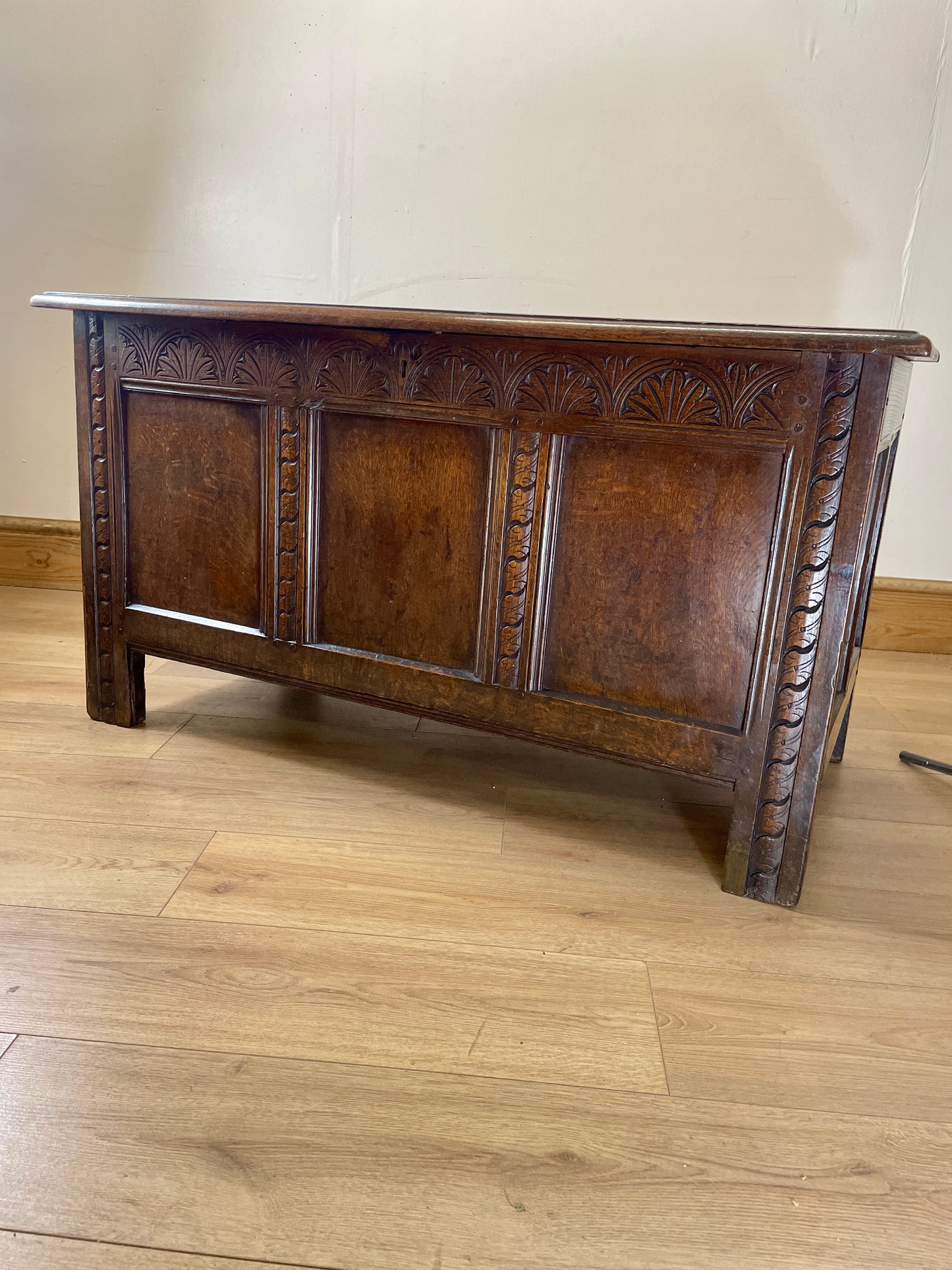 Wooden chest on a wooden floor with a plain wall background