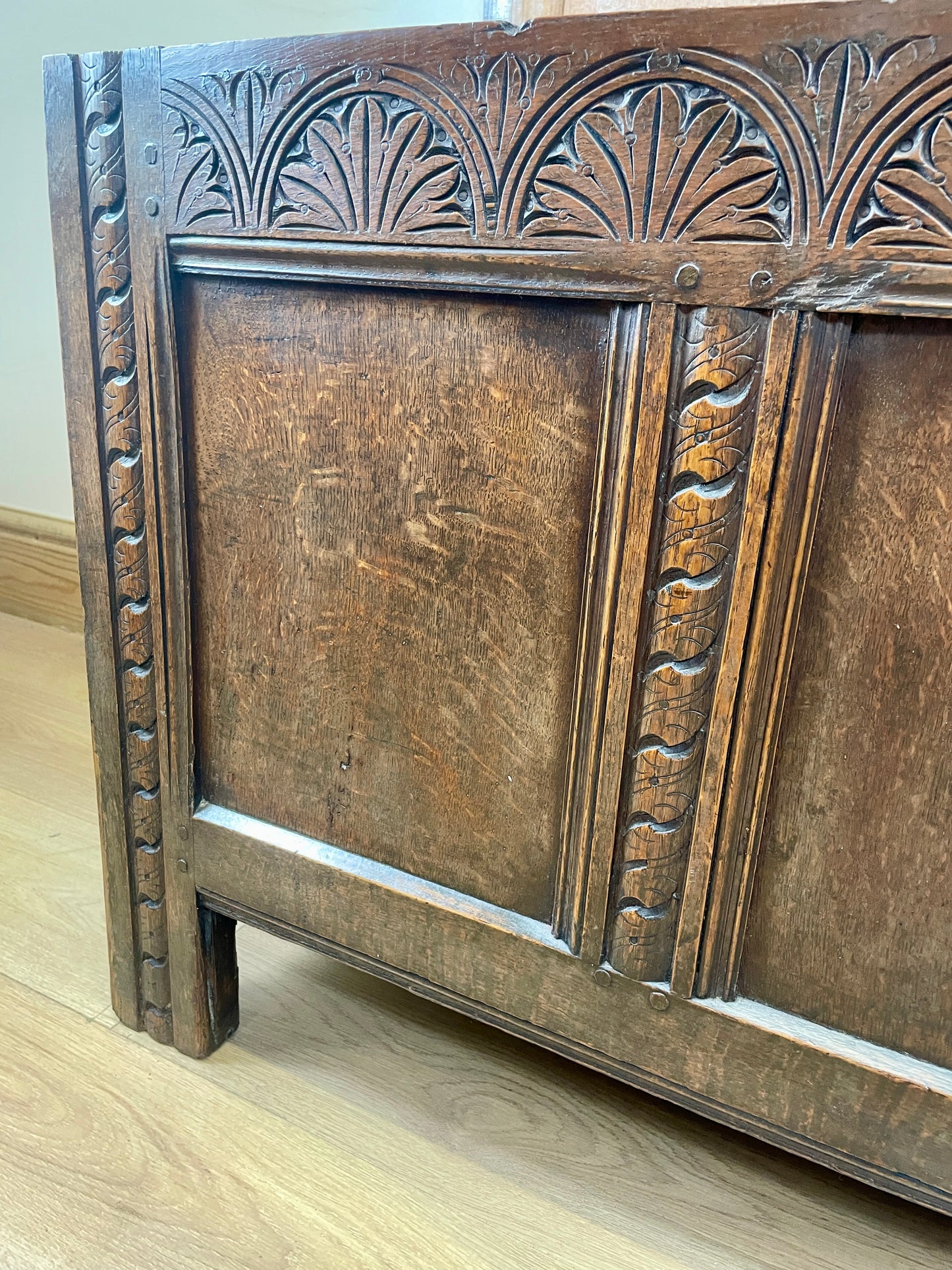 Wooden panel with intricate carvings on a light wooden floor