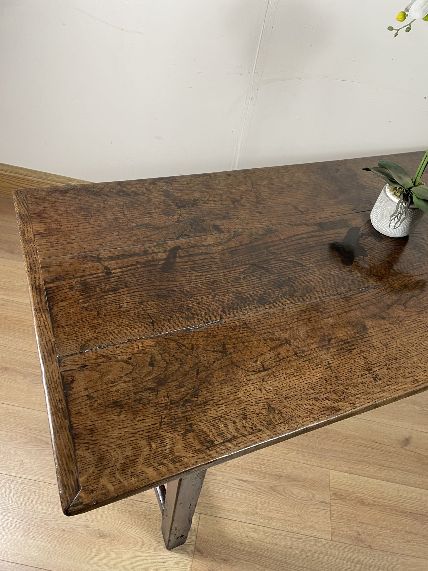 Wooden table with a rustic finish on a light wooden floor.