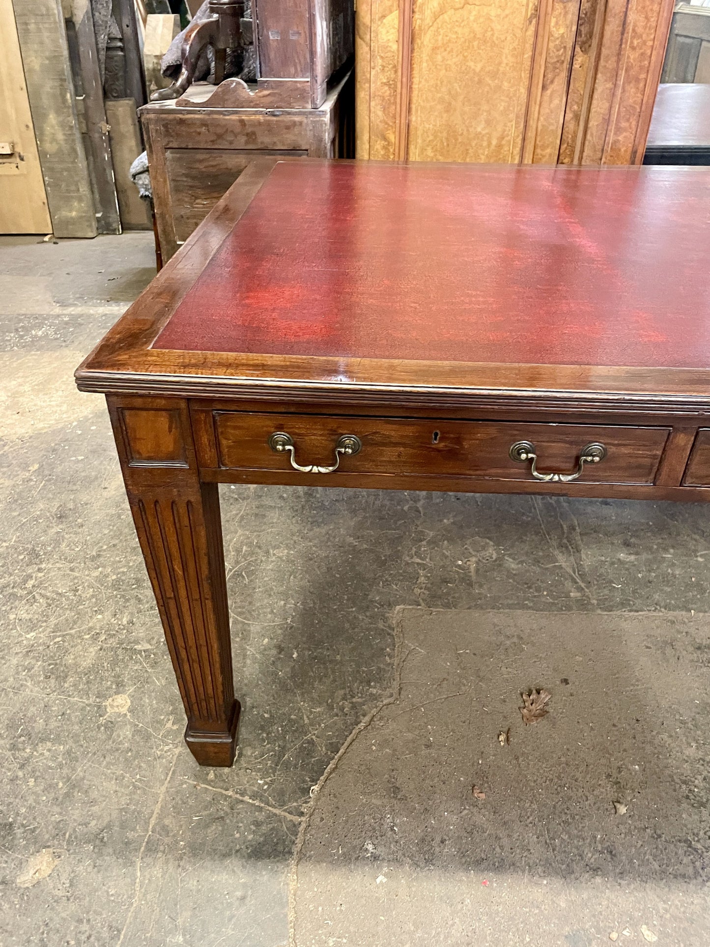 Wooden desk with leather top on a stone floor