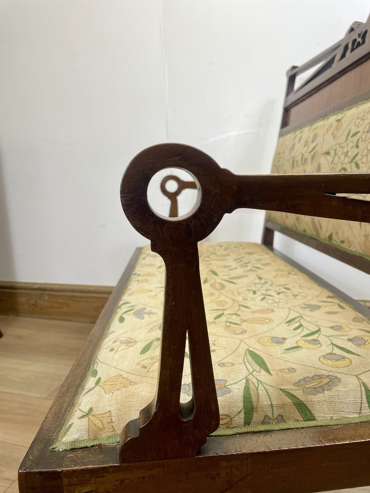 Wooden chair with floral cushion and logo on backrest