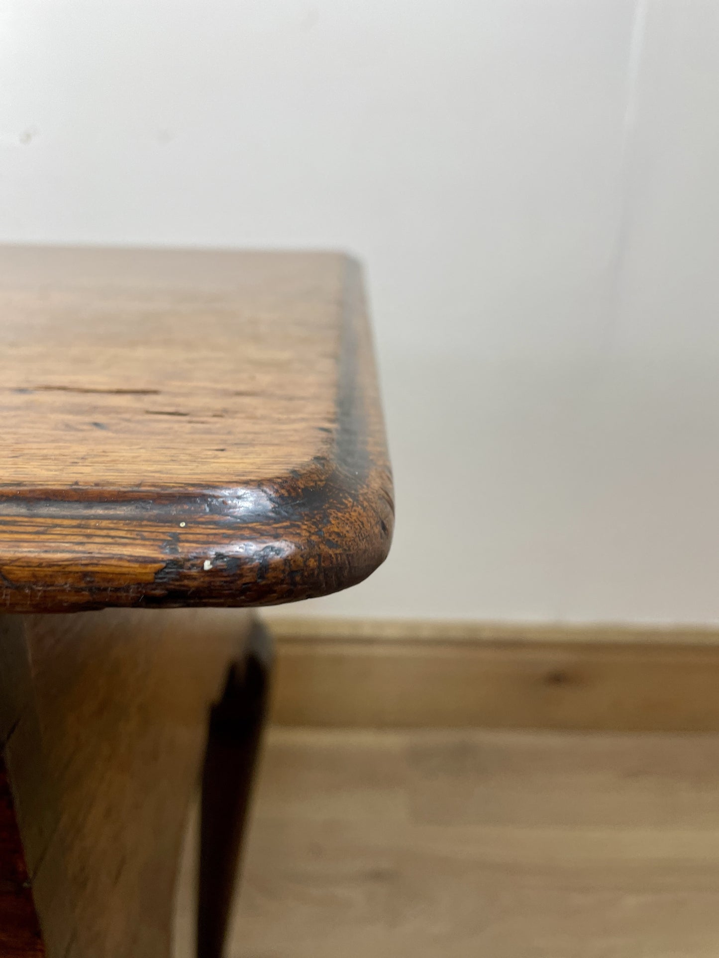Wooden stool with a worn surface on a plain background