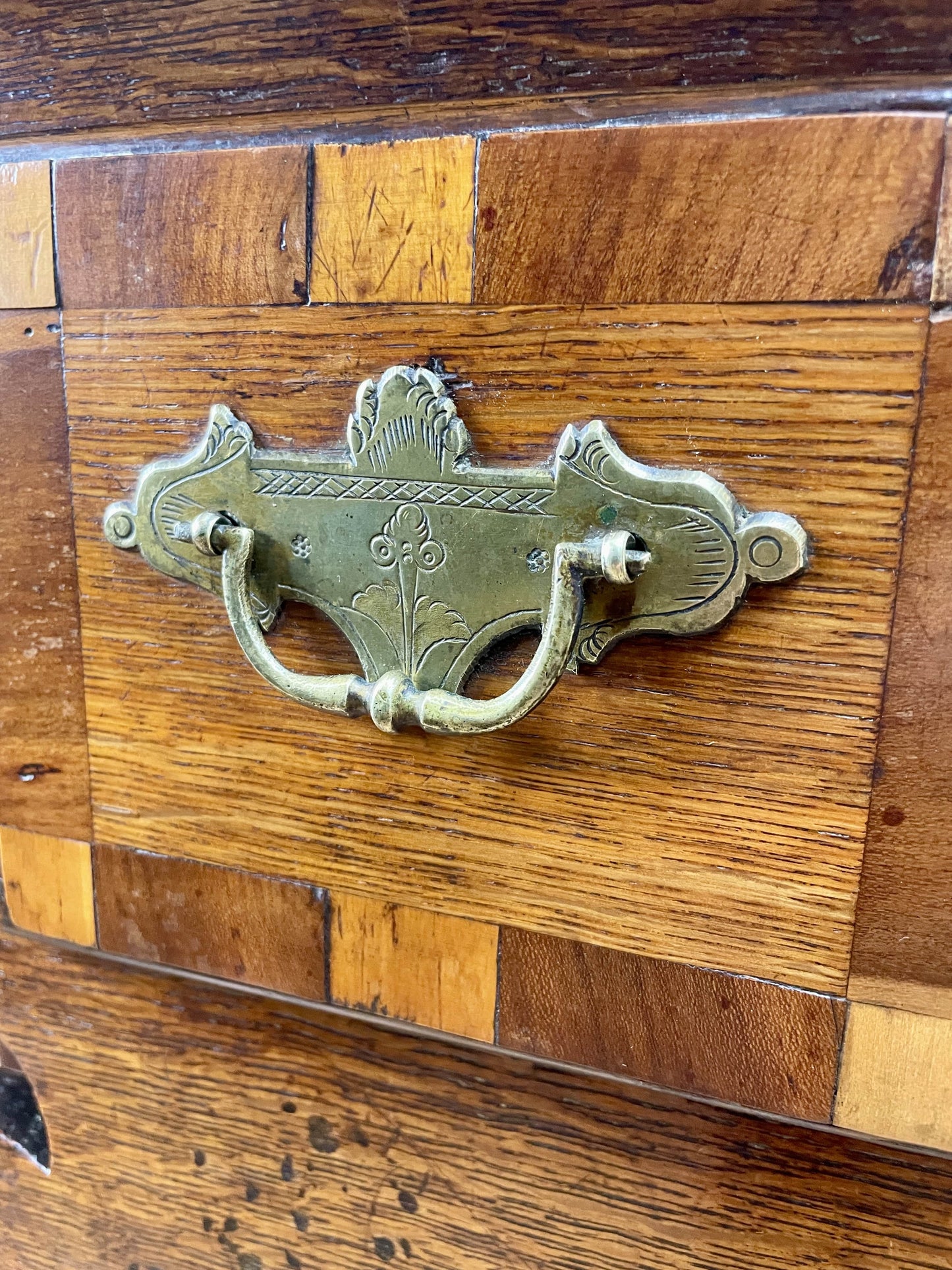 Decorative brass handle on a wooden surface