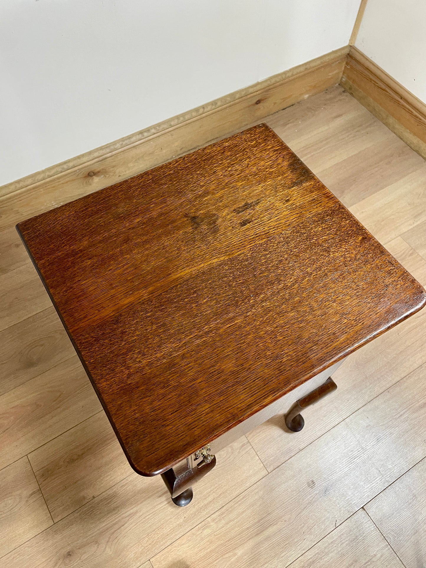Wooden nightstand with wheels on a wooden floor