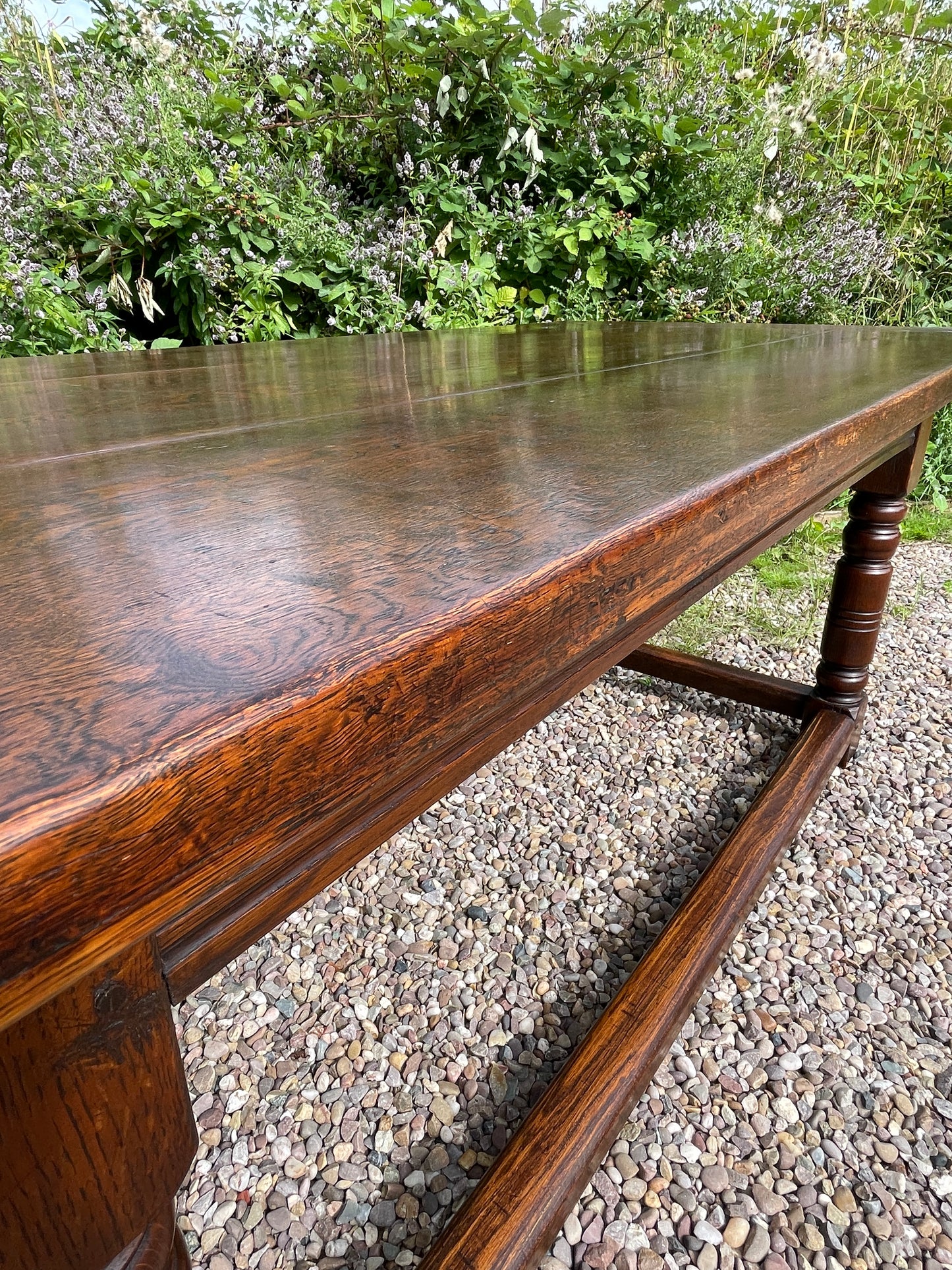 Wooden bench with a textured surface on a gravelly ground