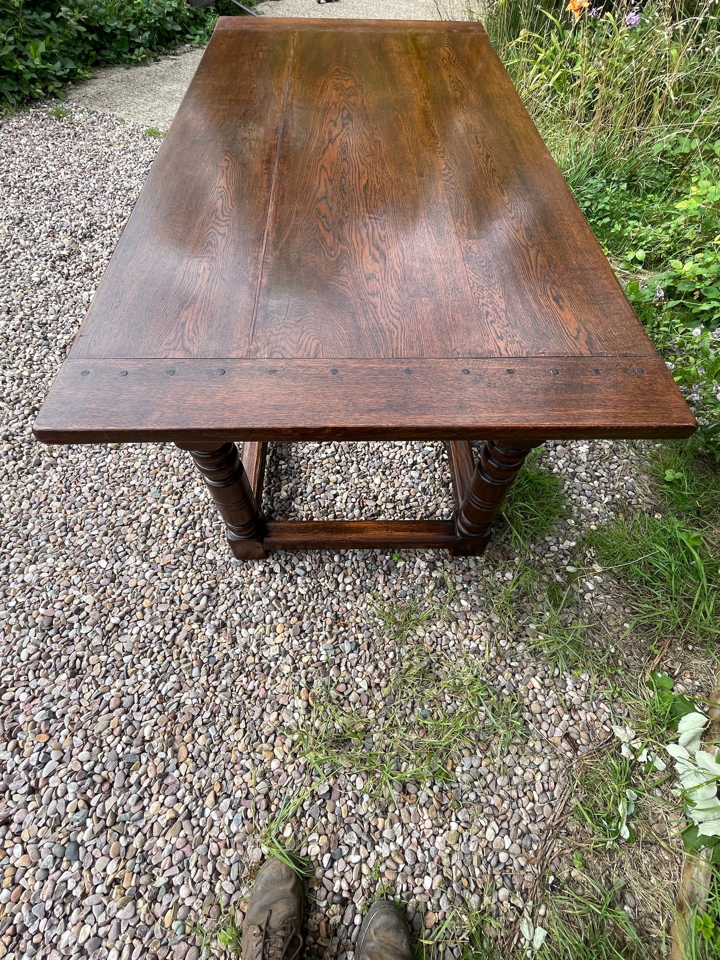 Wooden table outdoors on a gravel surface with grass in the background