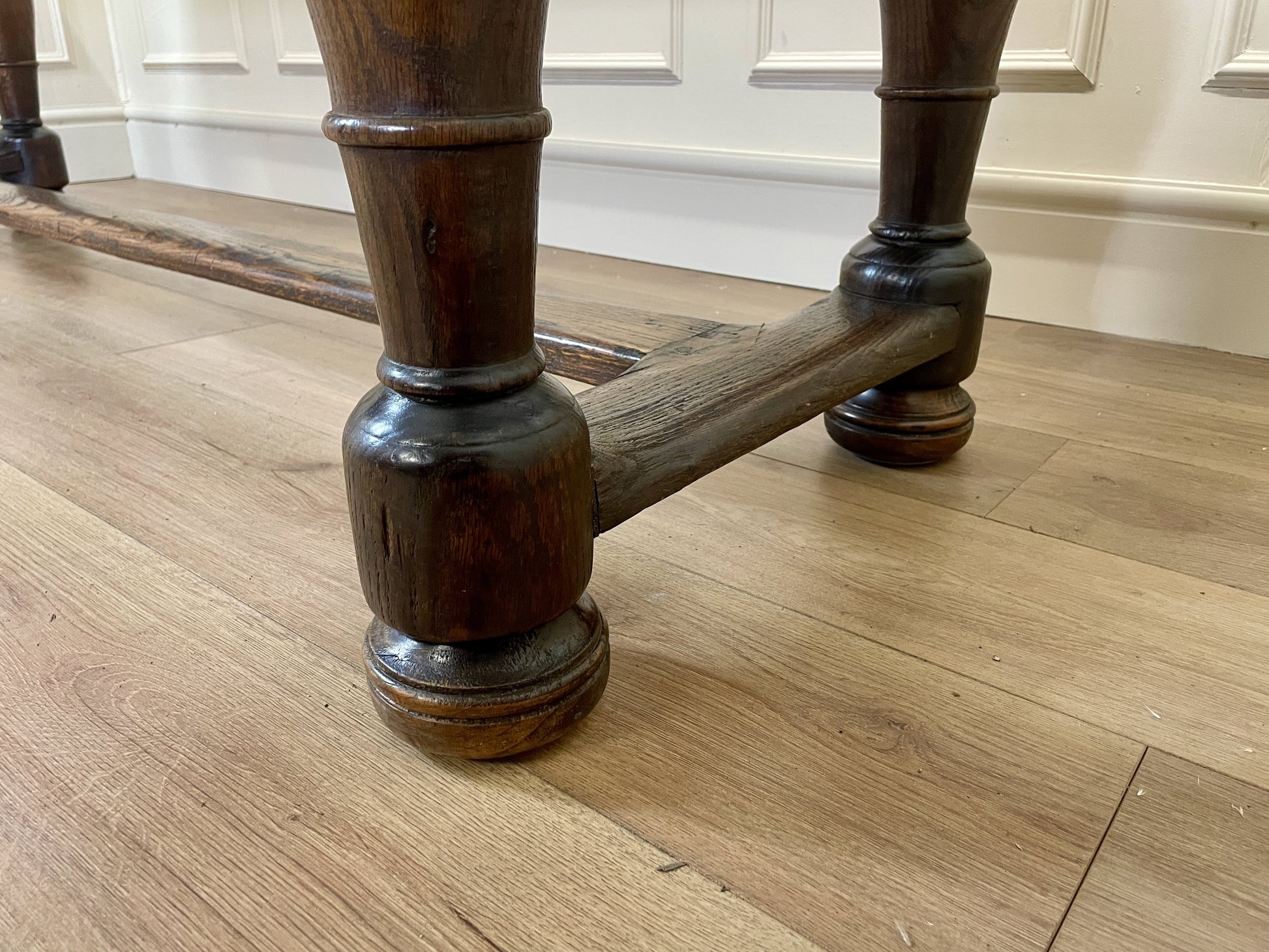 Wooden legs of a piece of furniture on a wooden floor