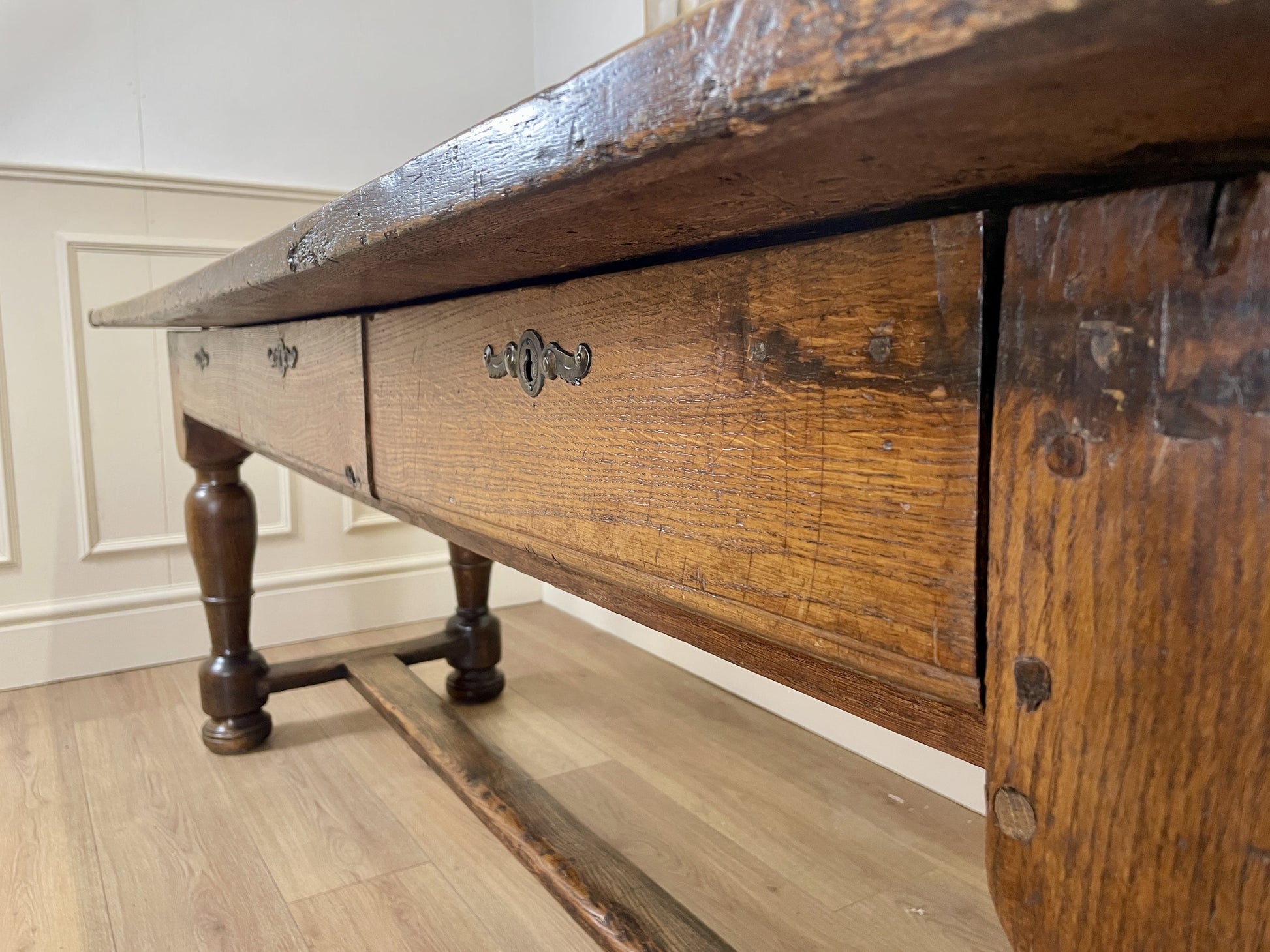 Wooden dresser with a drawer open on a wooden floor.