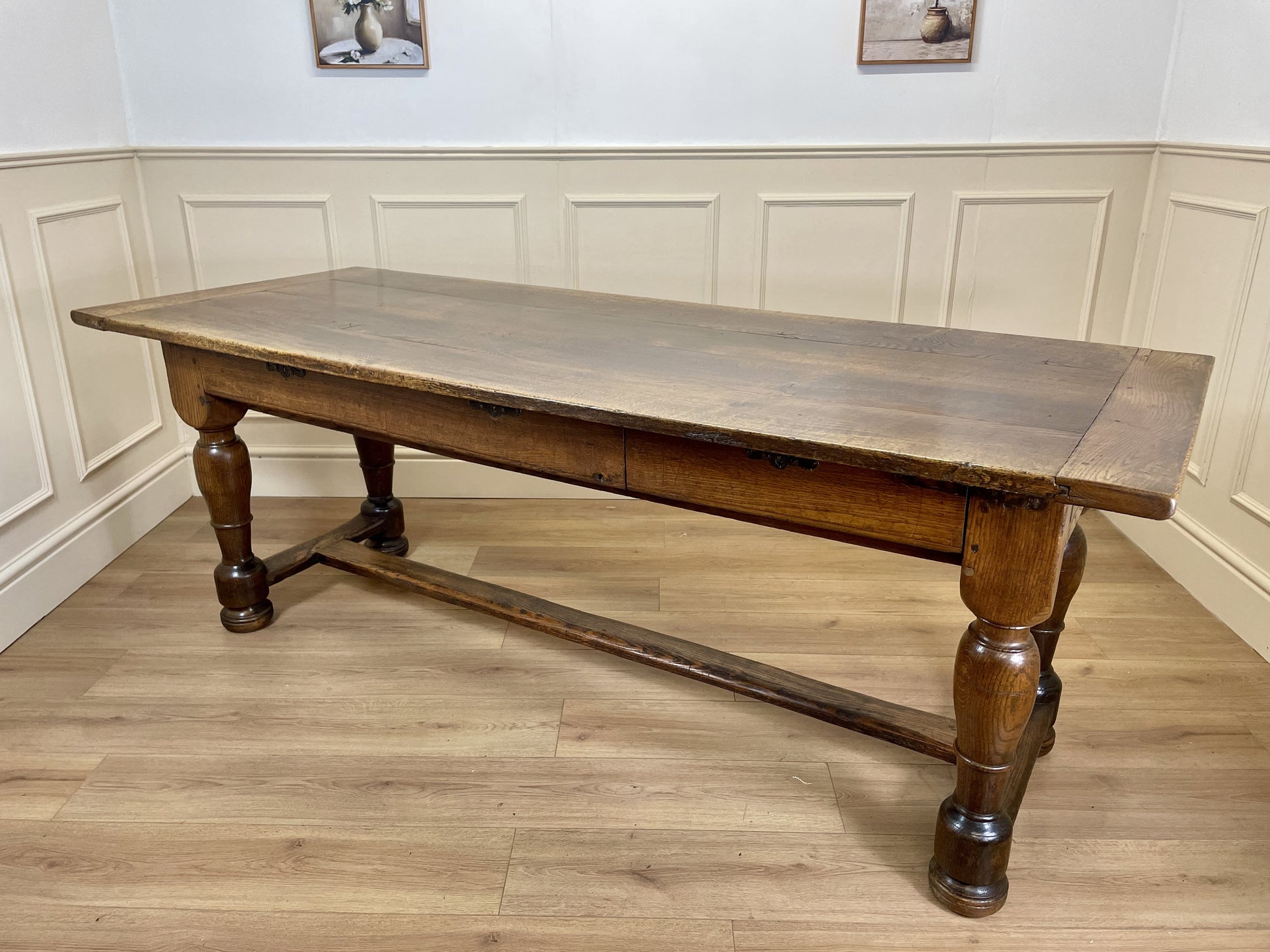 Wooden table with a rustic design in a room with panelled walls and wooden flooring.
