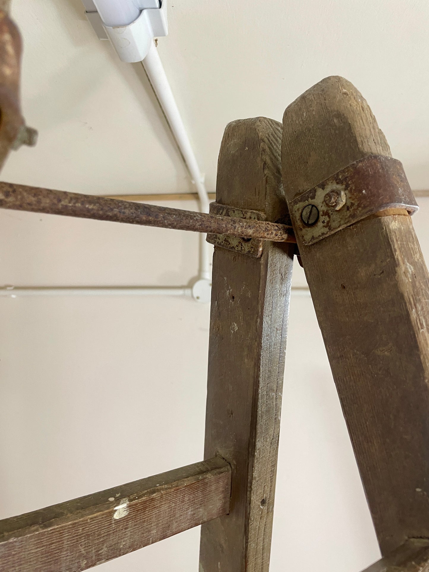 Close-up of a wooden ladder with metal rungs on a white background