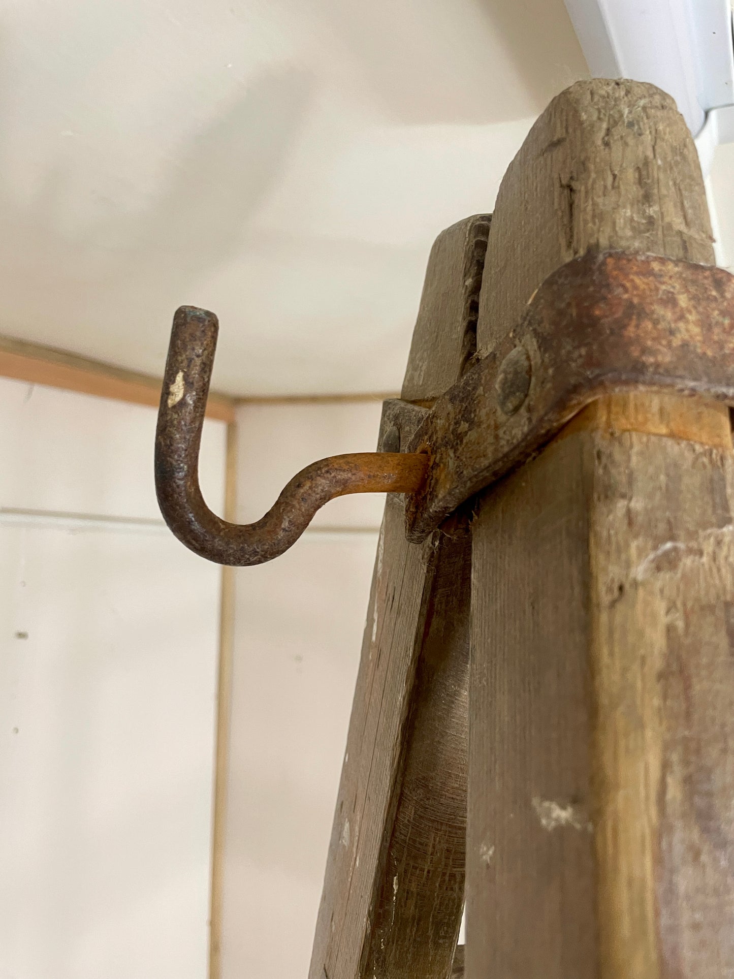Rustic wooden hook with a metal hook on a wooden surface.