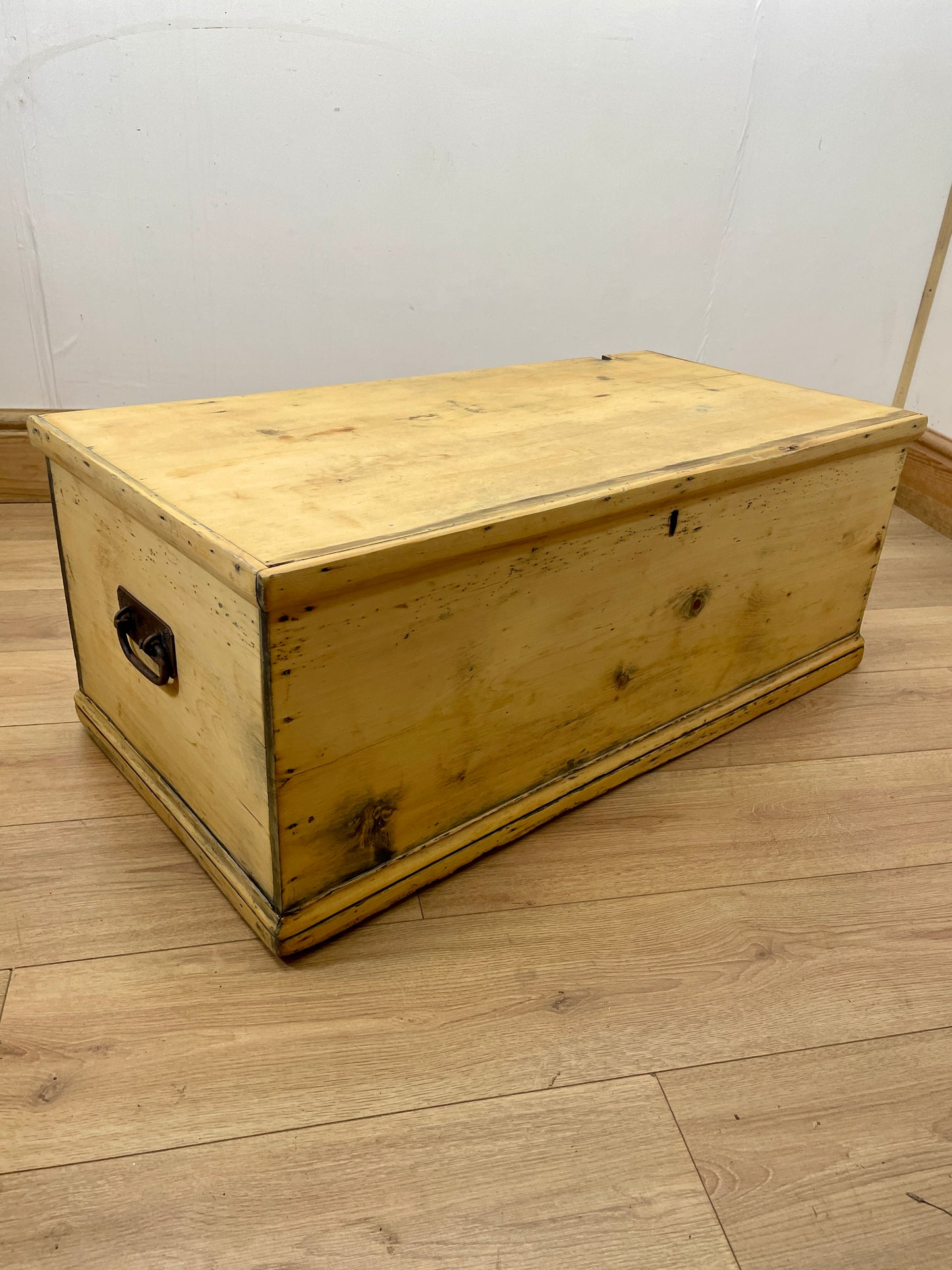 Wooden chest on a wooden floor with a white wall background