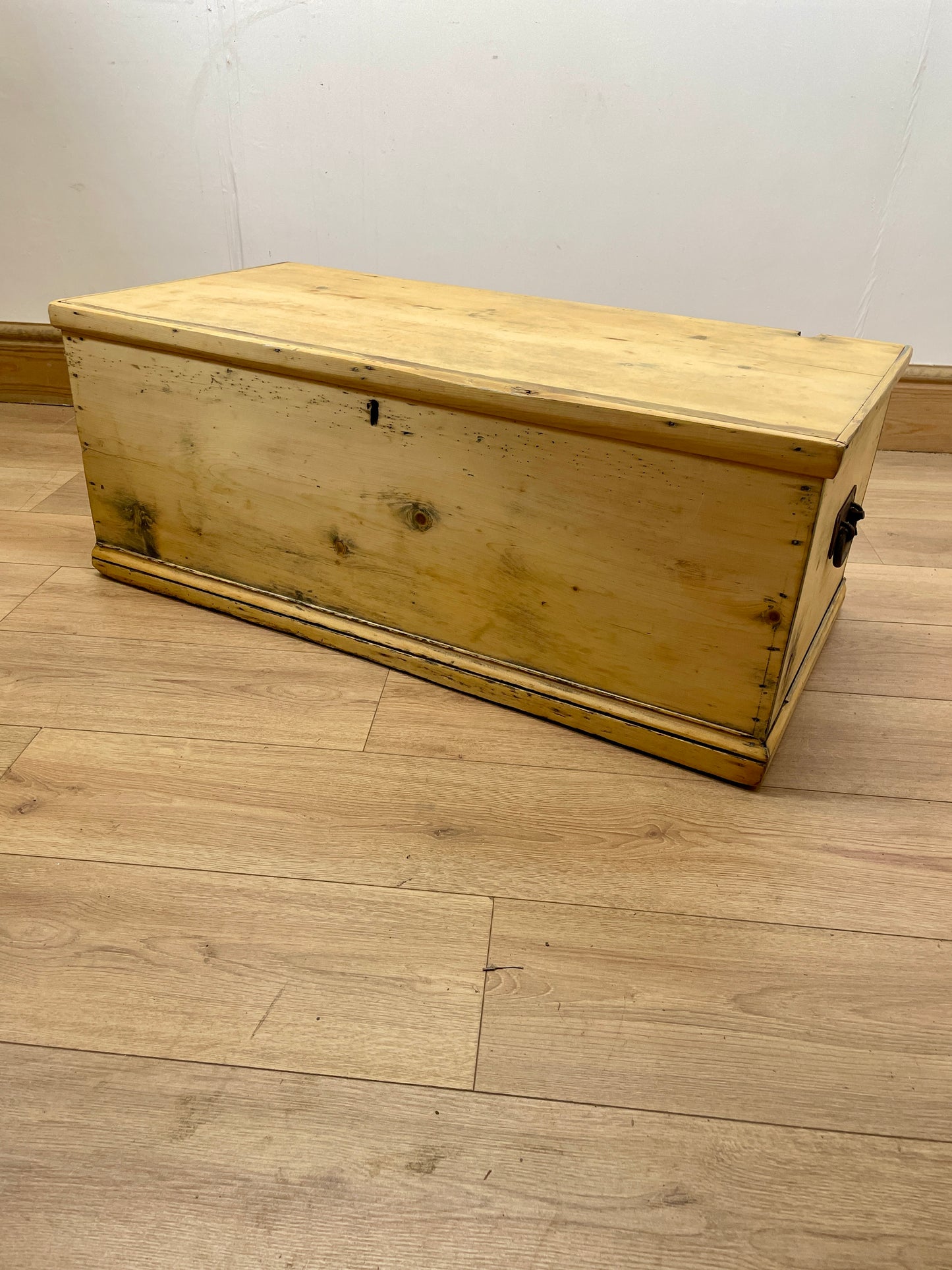 Wooden chest on a wooden floor with a white wall background