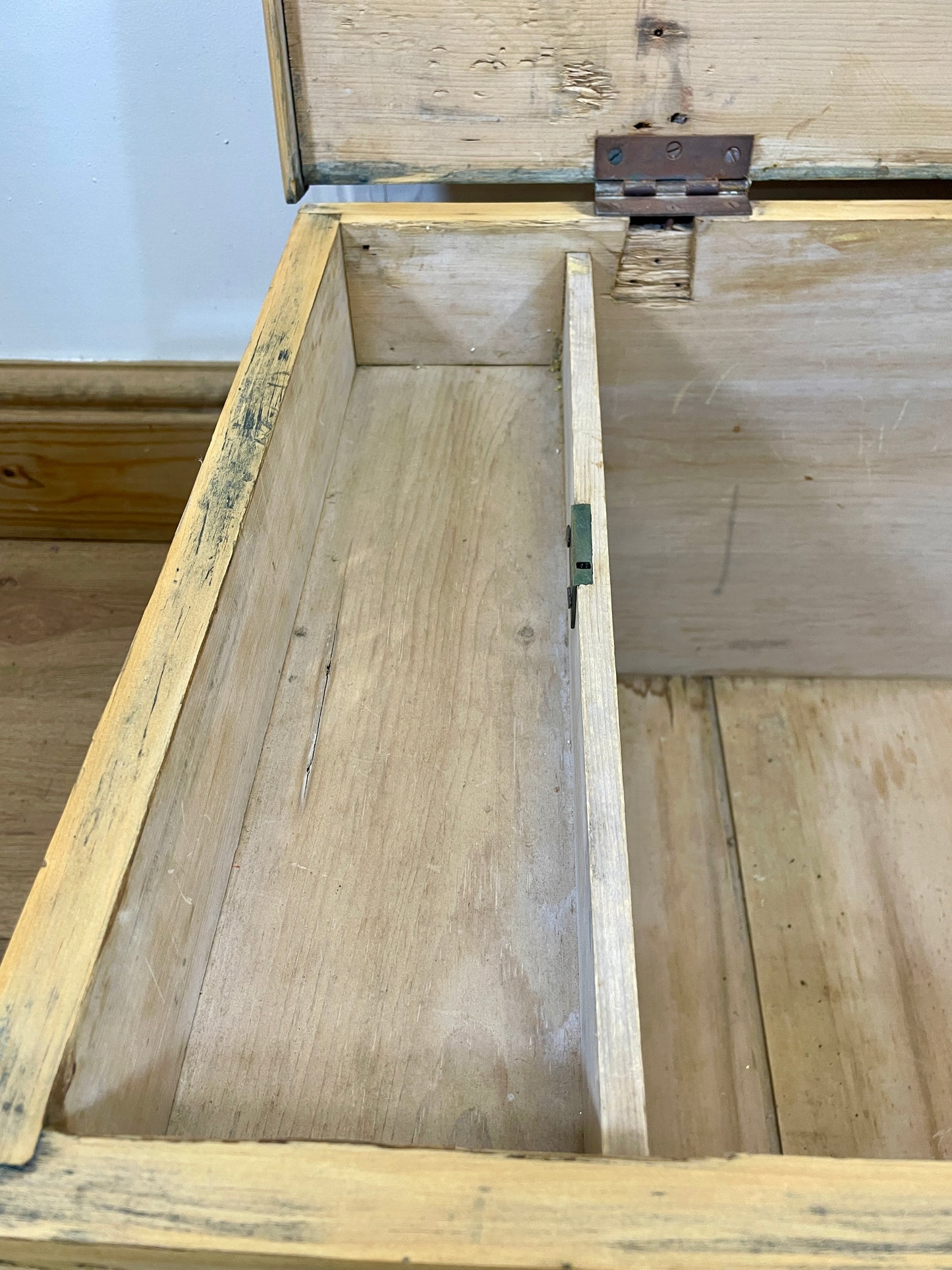 Wooden box with a lid open on a wooden floor