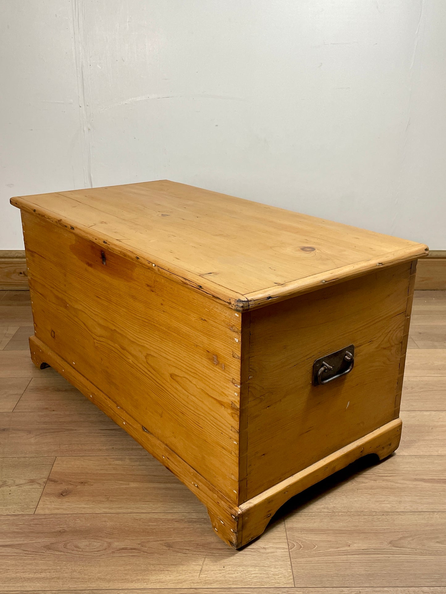 Wooden chest on a wooden floor with a white wall background