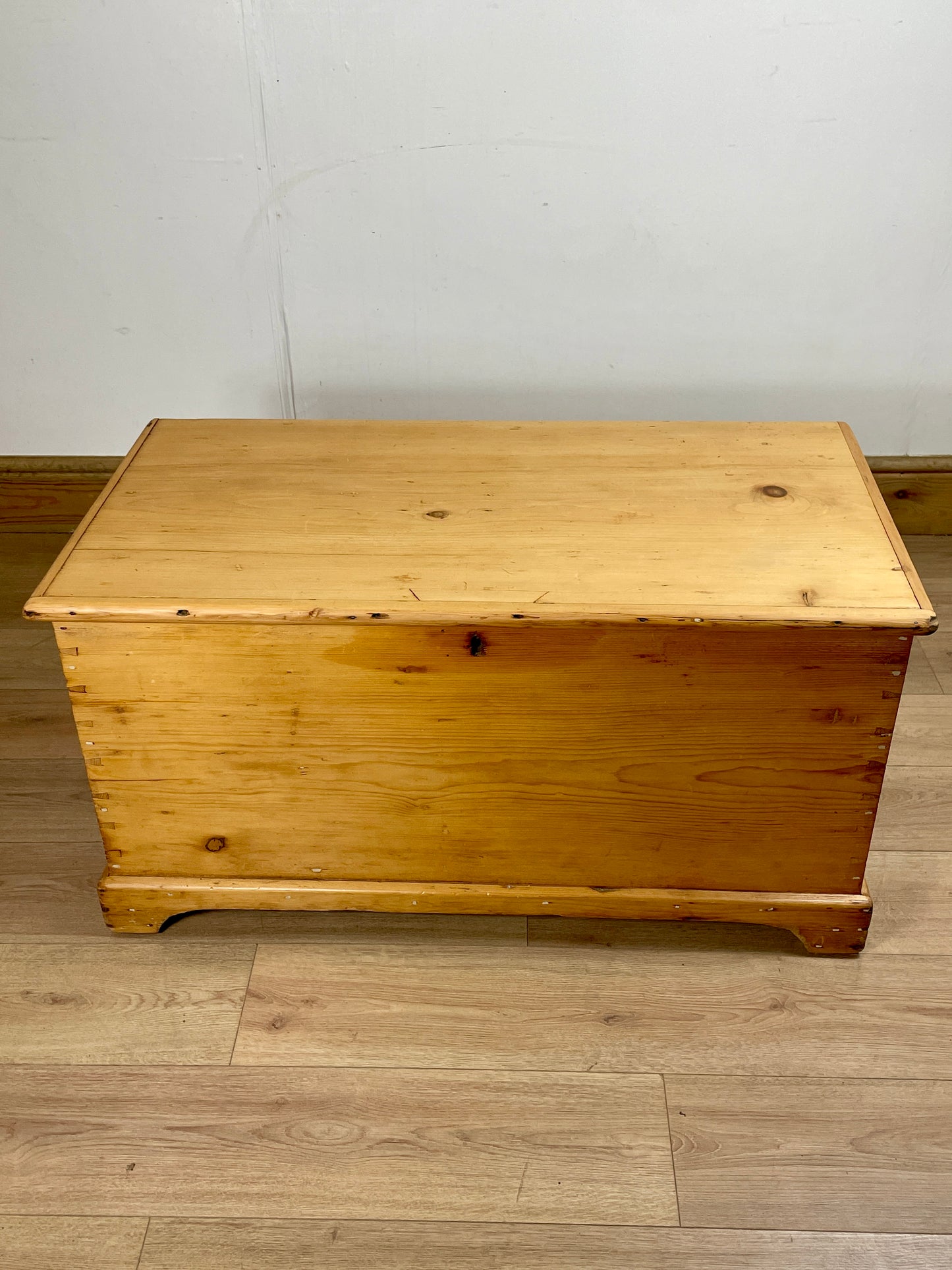 Wooden chest on a wooden floor with a white wall background