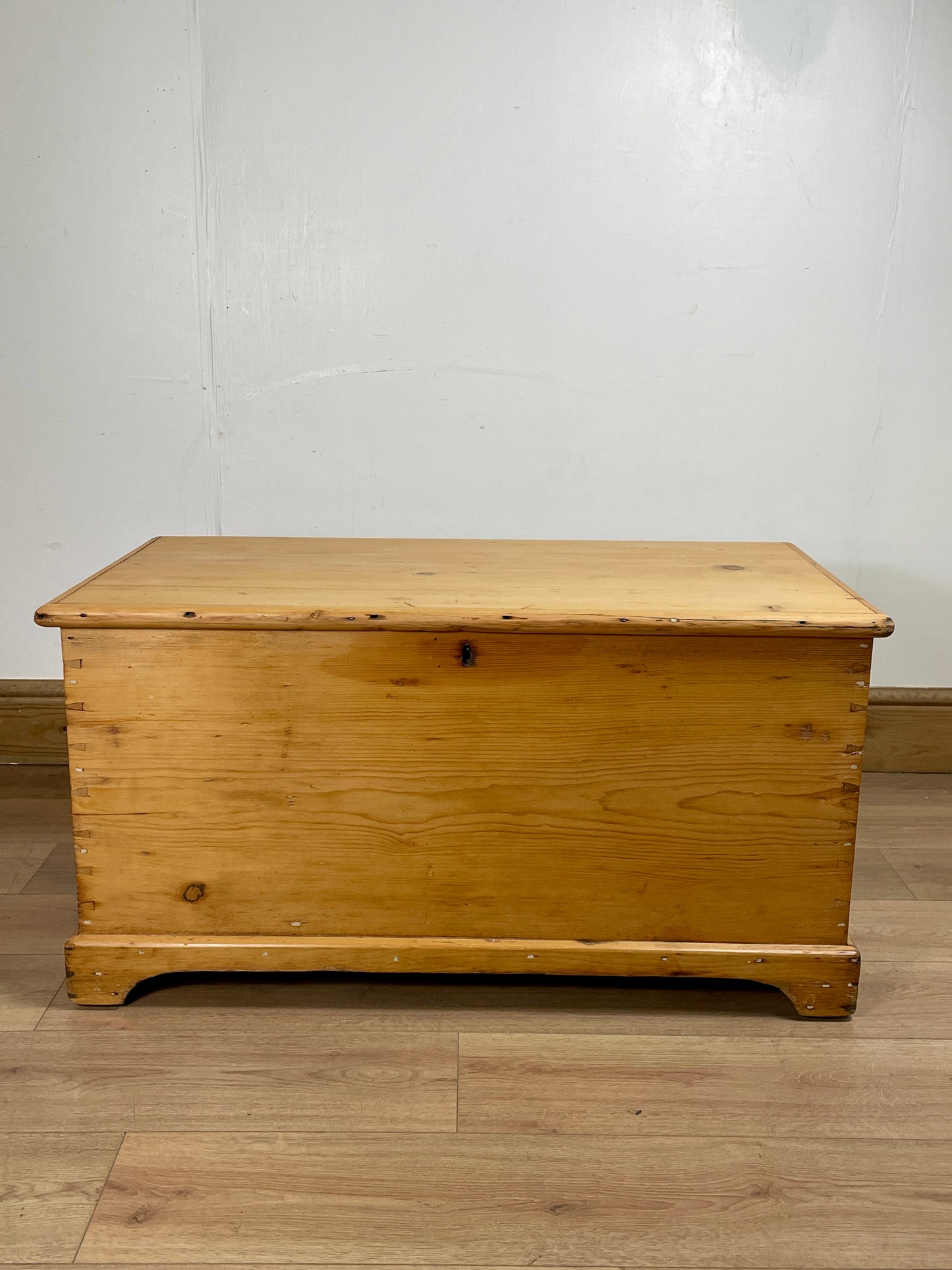 Wooden chest on a wooden floor with a white wall background